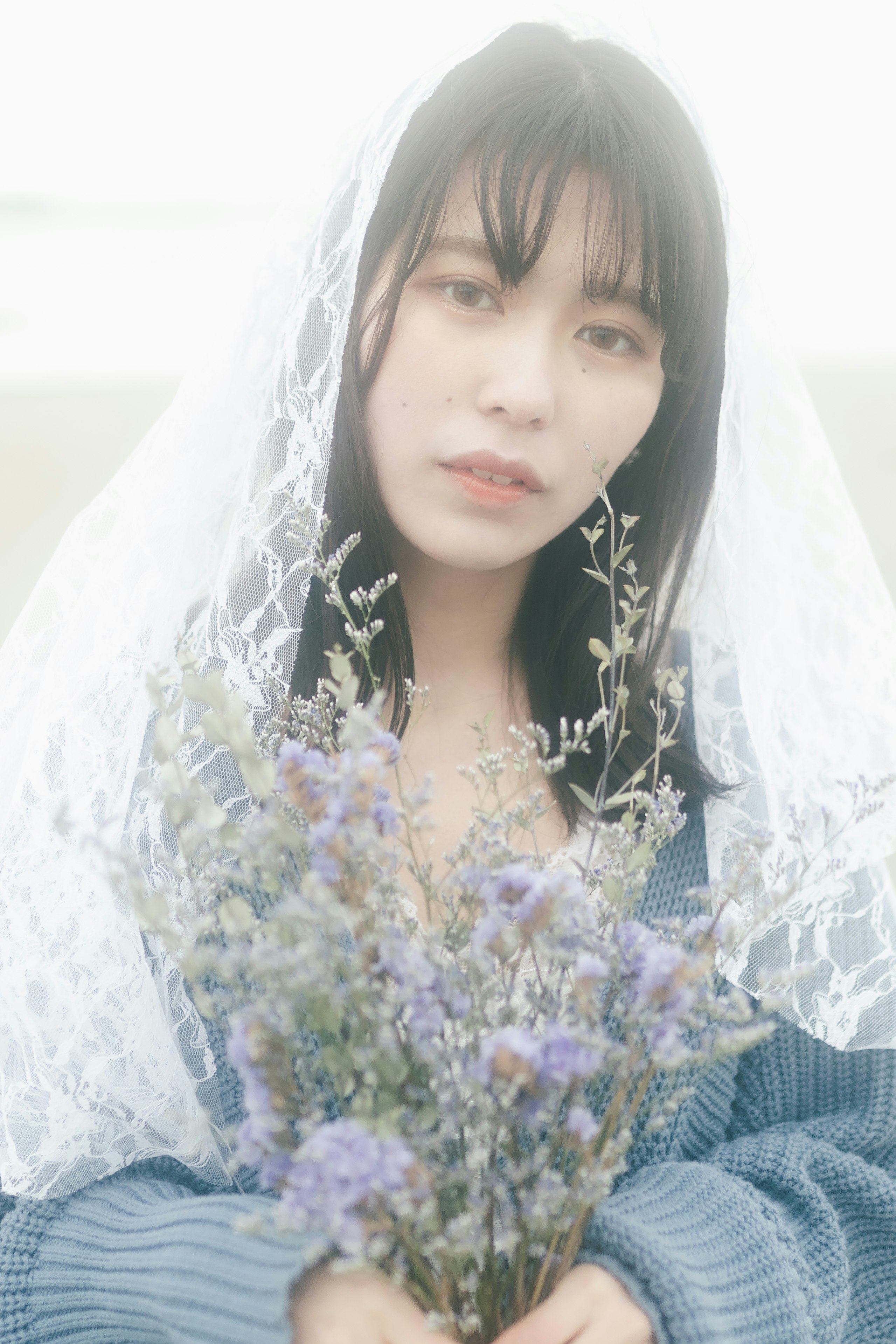 白いベールと花束を抱える女性のポートレート