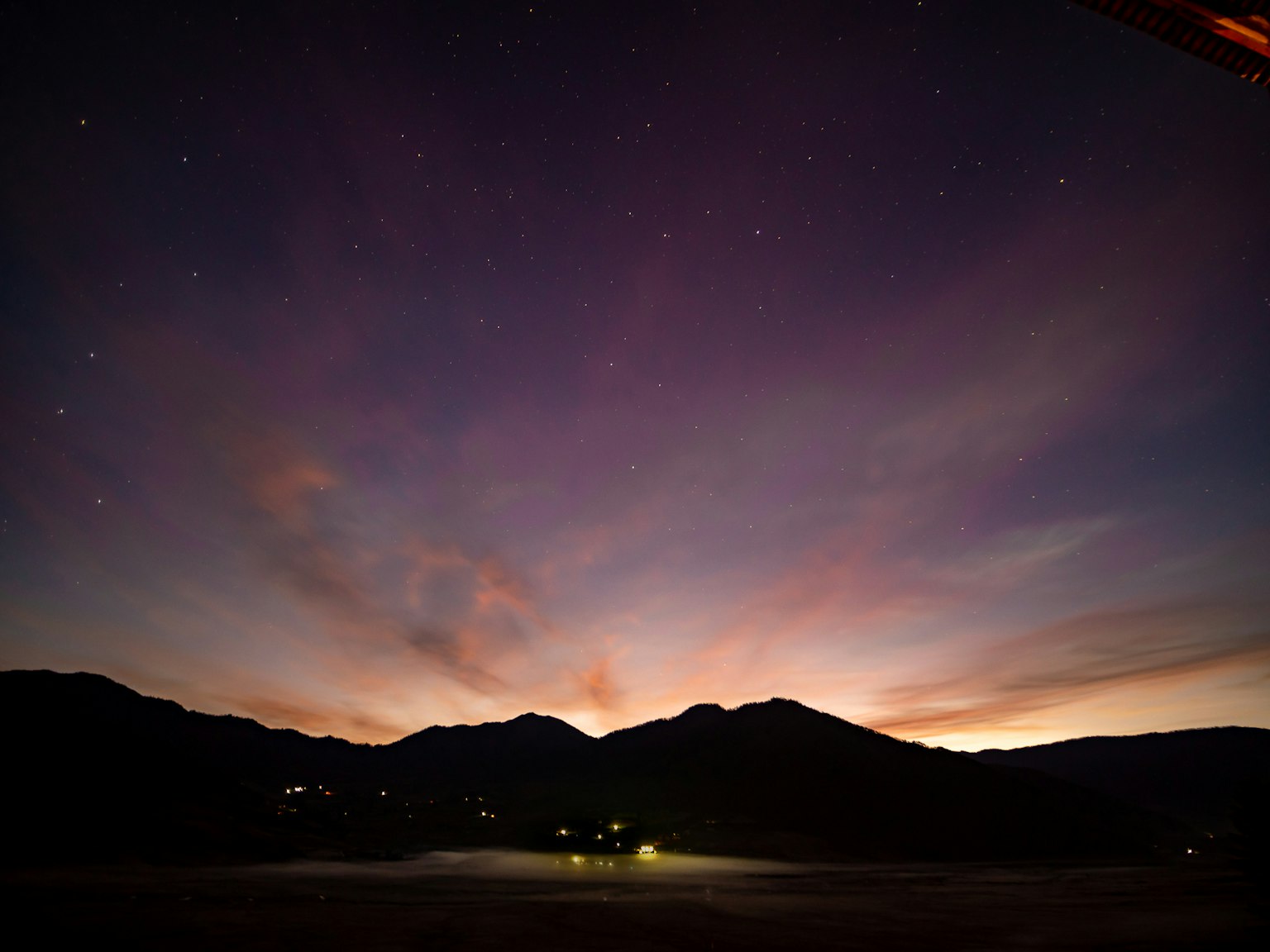 Beautiful sunset landscape with mountain silhouettes and starry sky