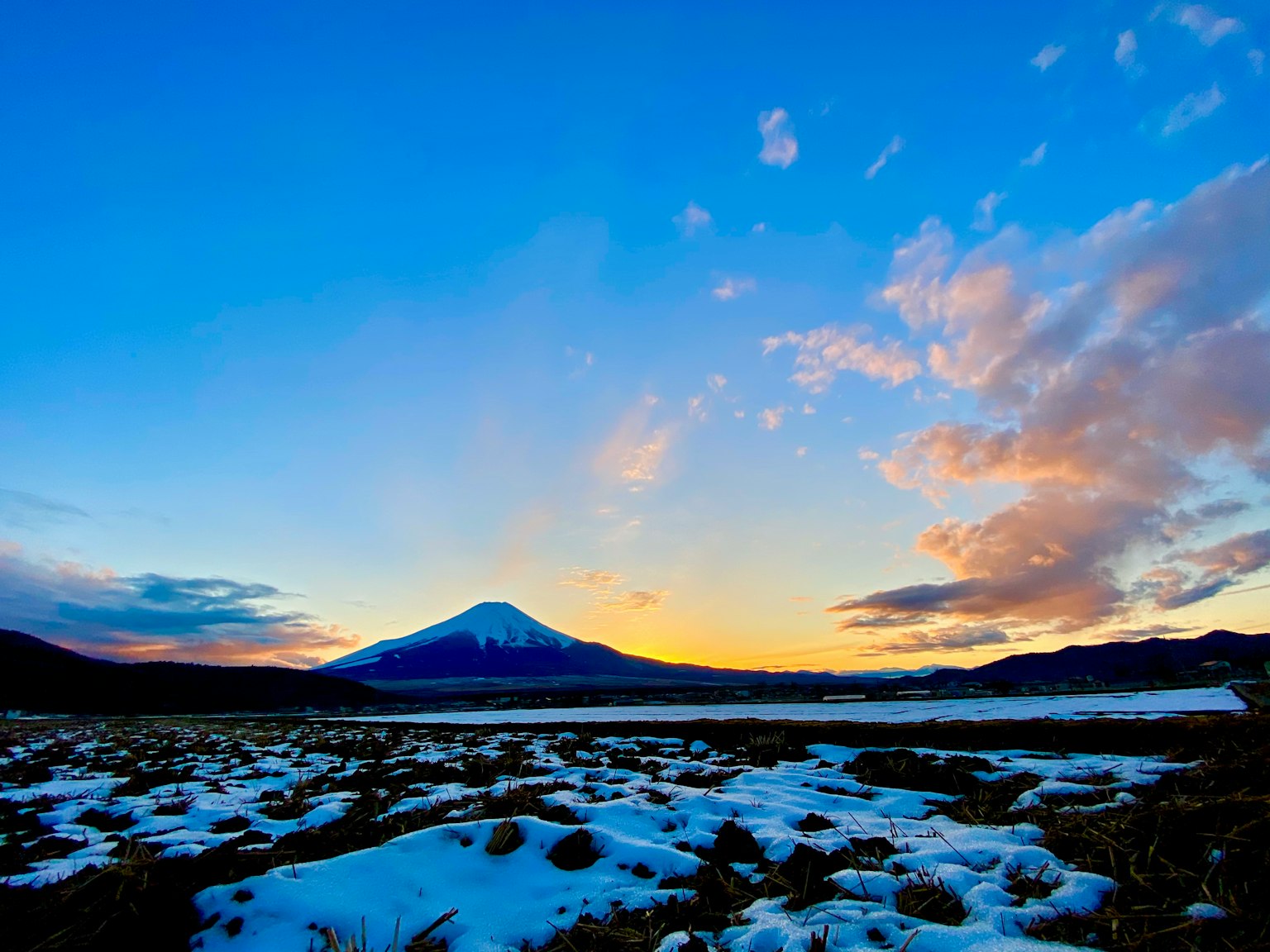 Schneebedeckter Berg mit blauem Himmel und Sonnenuntergang