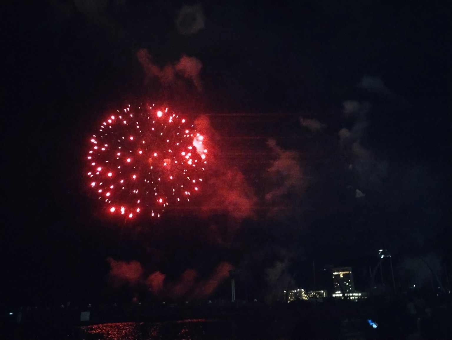 夜空中绽放的红色烟花和烟雾