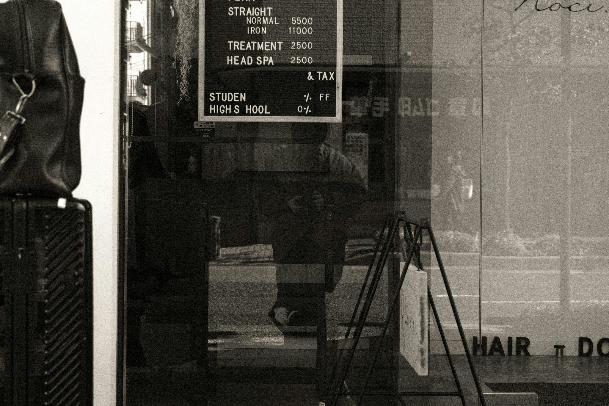 papan toko barbershop terlihat melalui kaca dengan tripod