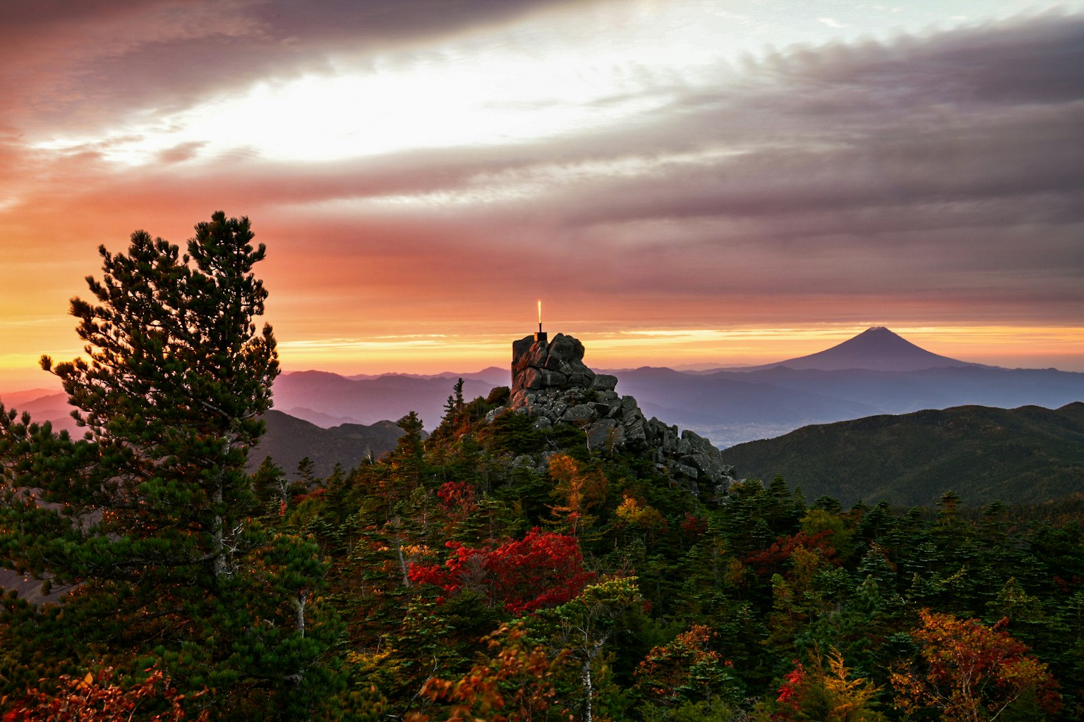 Rovine di un castello su una montagna al tramonto con montagne lontane