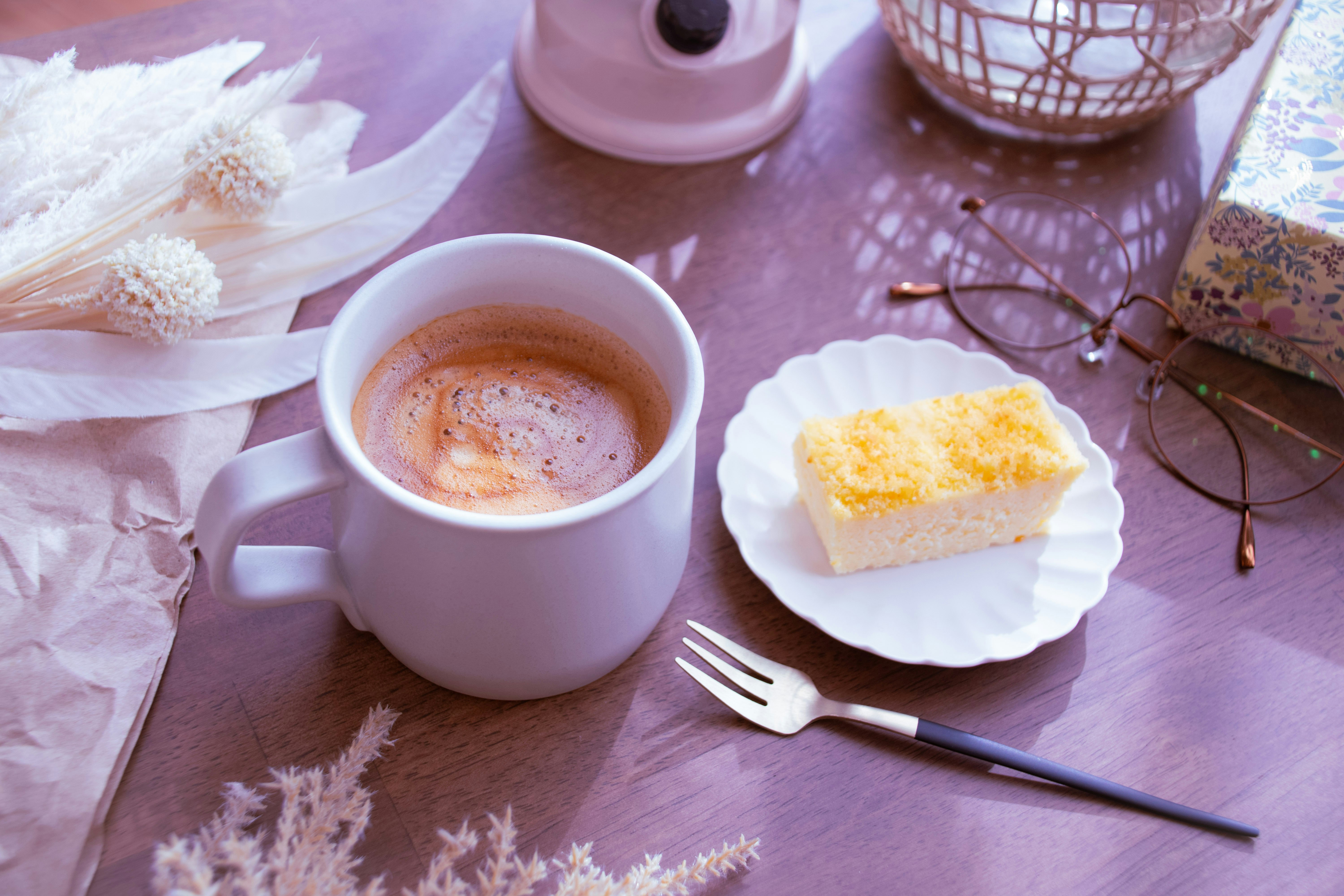 カップのコーヒーとケーキのあるティータイムのテーブル