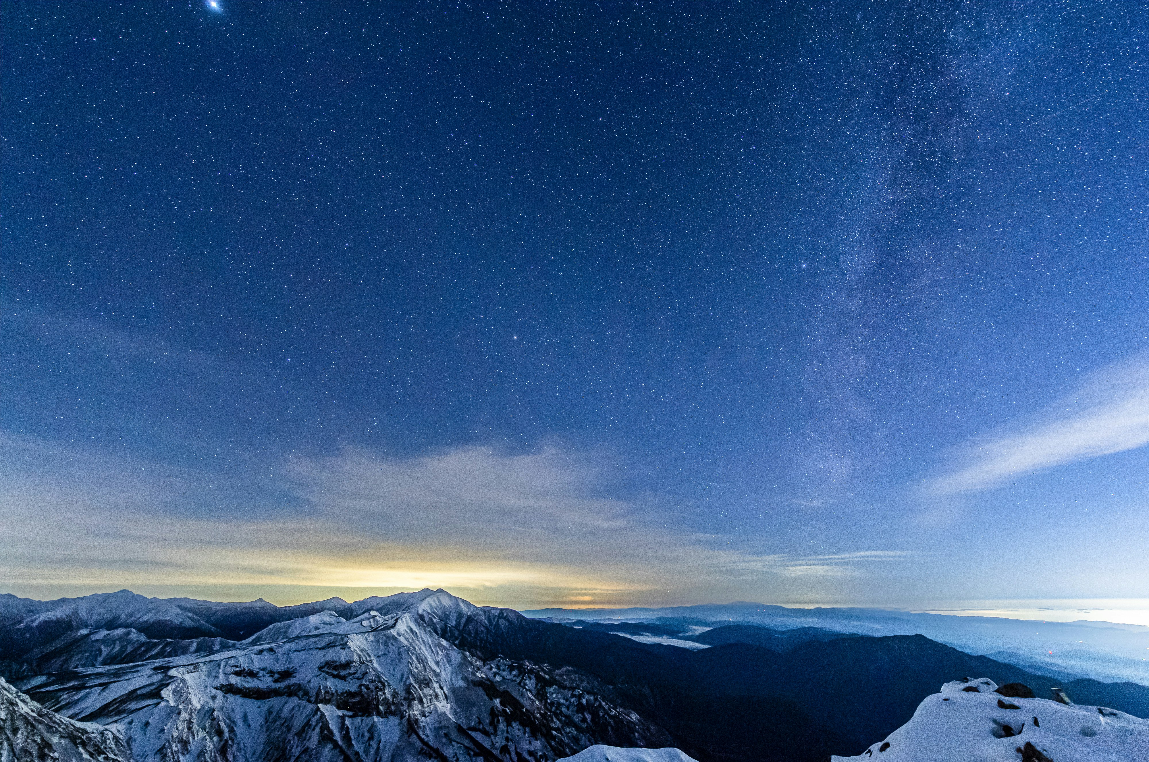 雪山の稜線と天の川が広がる夜空