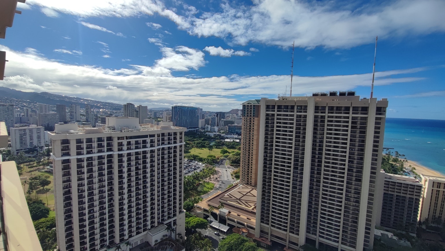 Panoramic view of Honolulu from a high-rise building blue sky and ocean green park visible