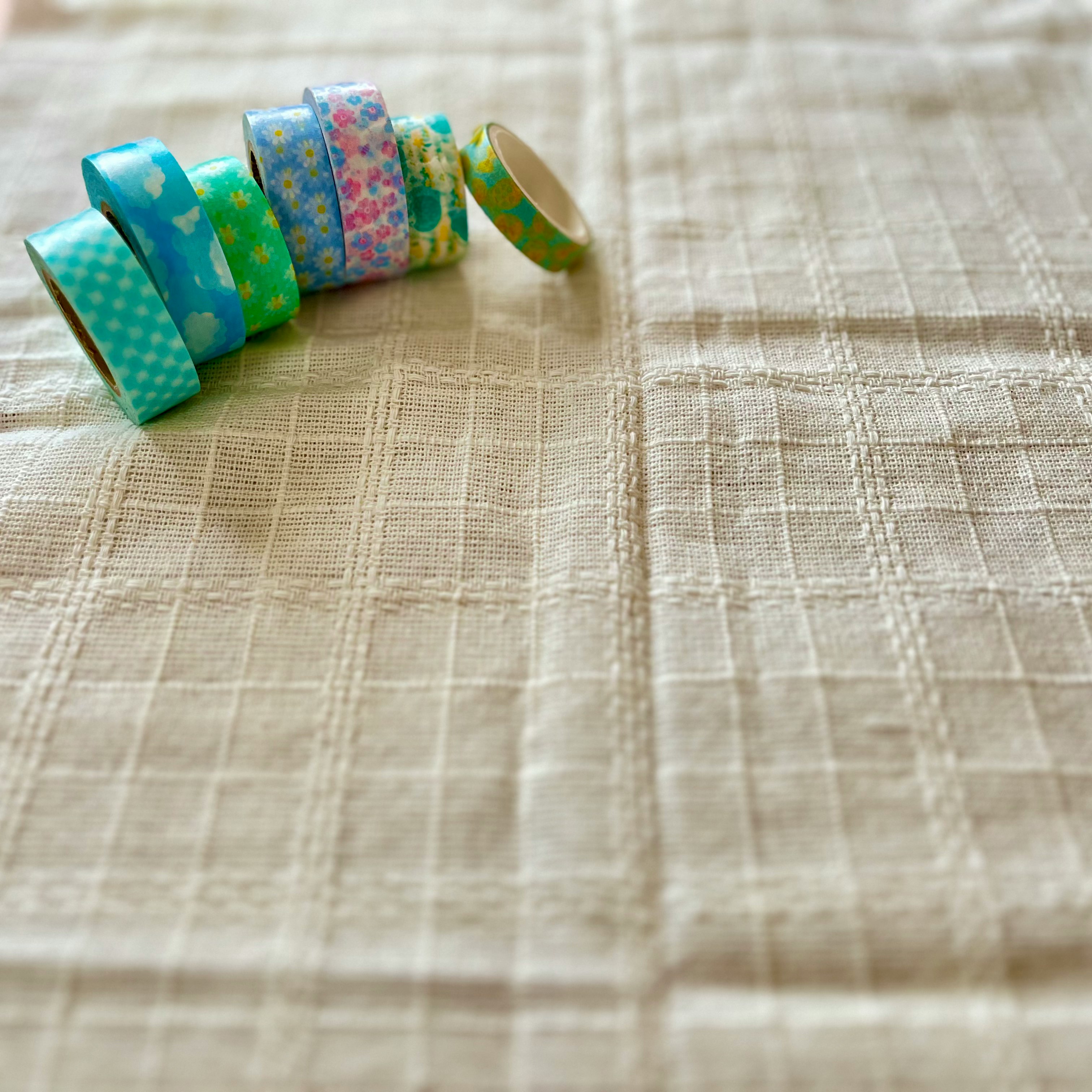 colorful gift ribbon rolls on beige fabric