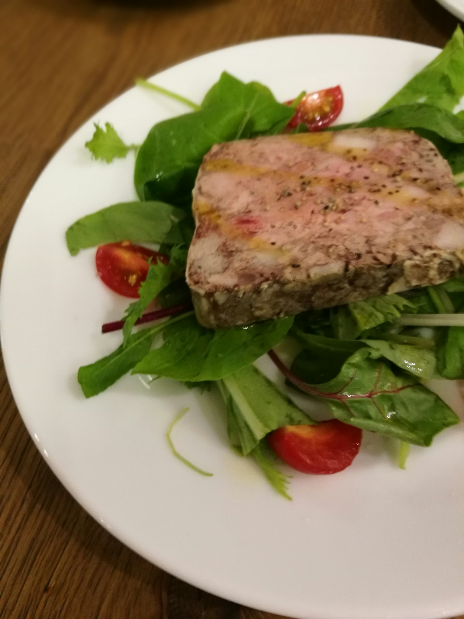 肉凍放在新鮮沙拉和櫻桃番茄上
