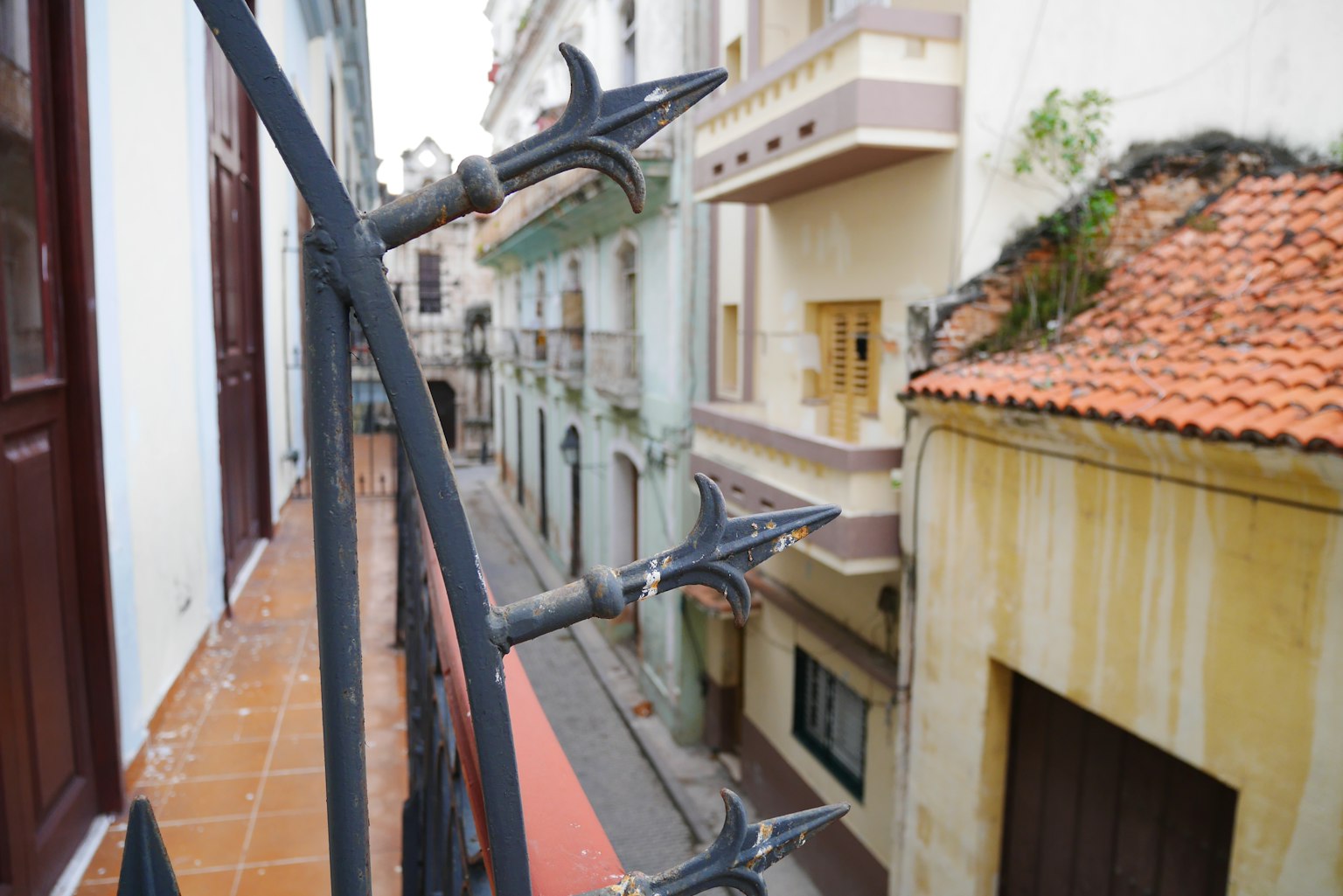 Vue colorée de la rue depuis un balcon avec garde-corps en fer forgé pointu