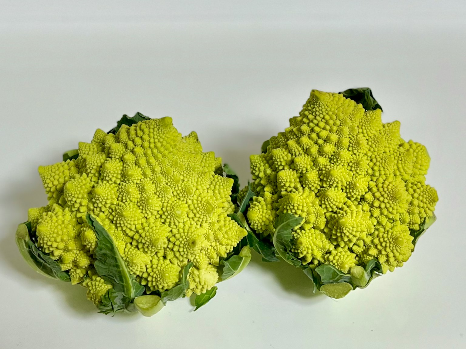 Hai đầu bông cải Romanesco xanh tươi được trưng bày bên cạnh nhau