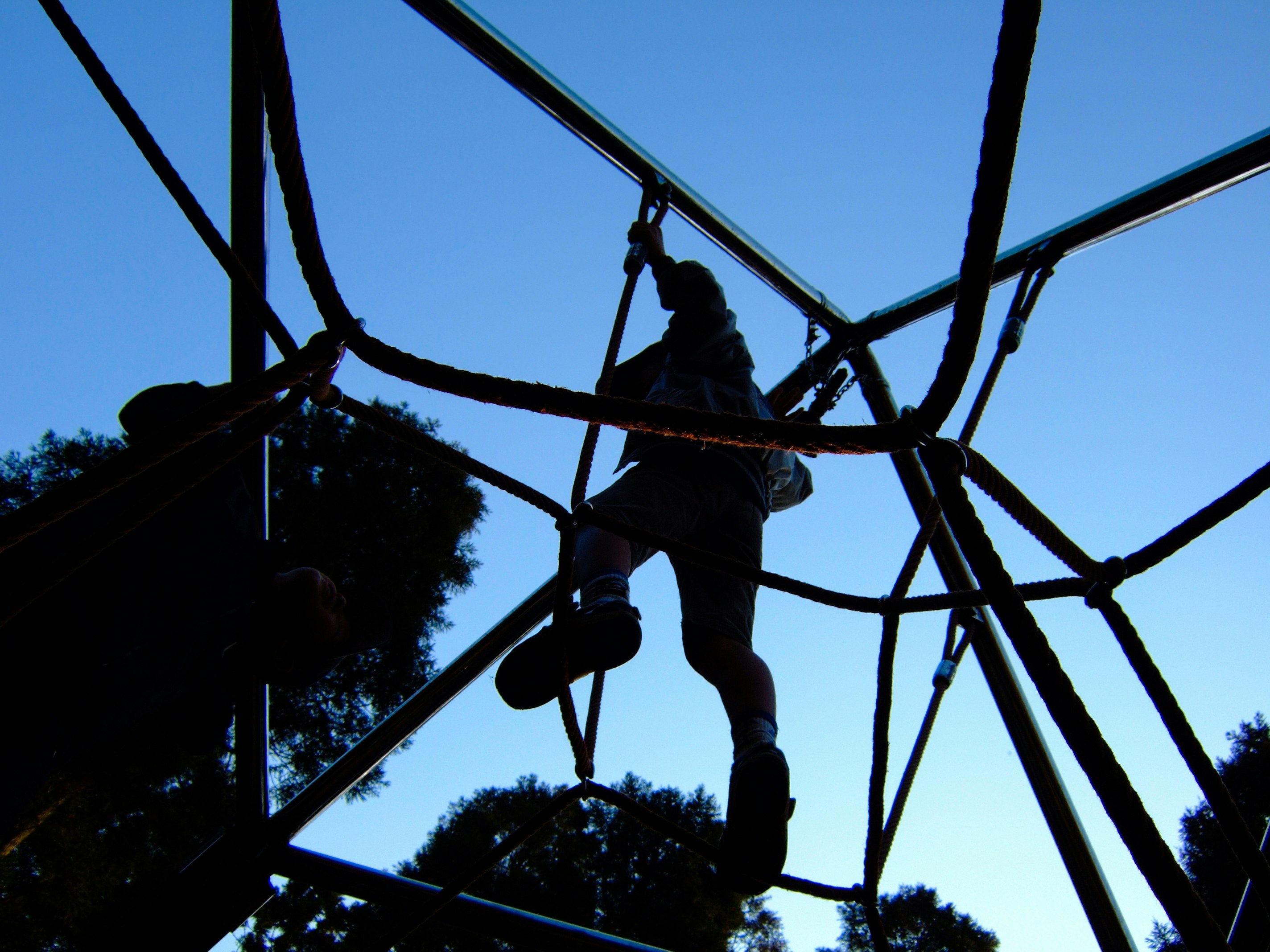 Silhouette eines Arbeiters auf einem Kran vor blauem Himmel