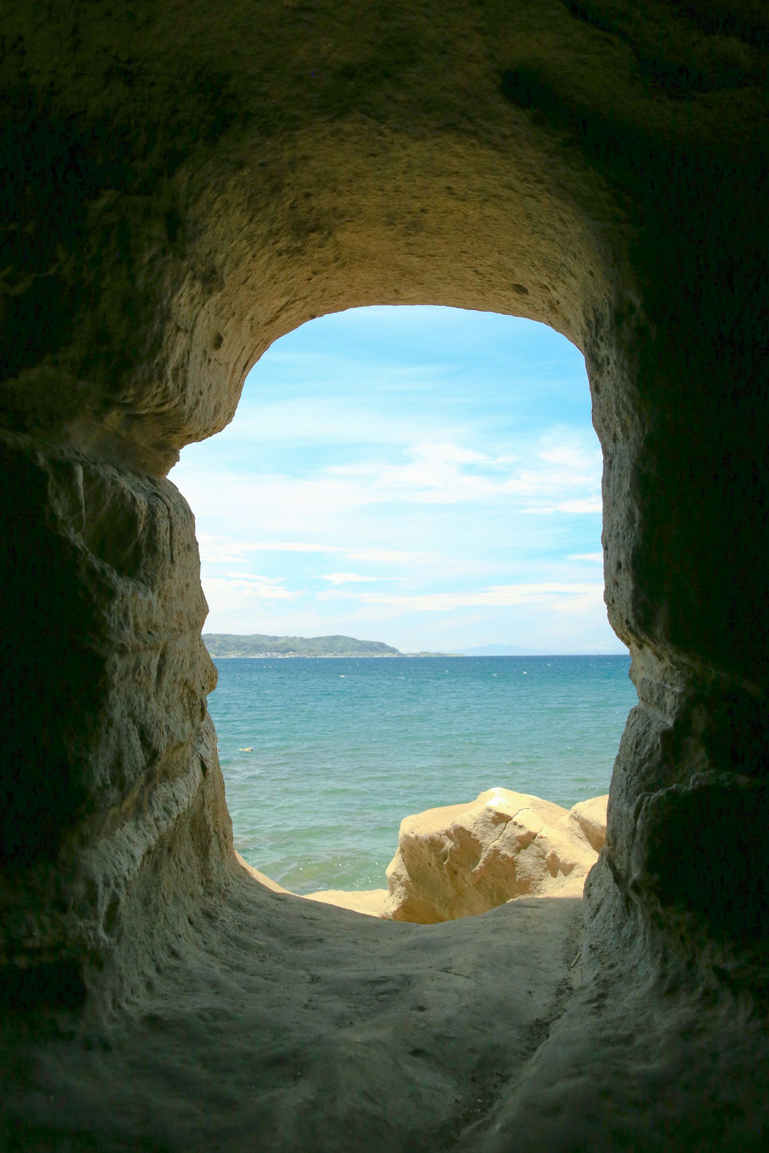 Vista del mar y del cielo azul a través de una apertura de cueva