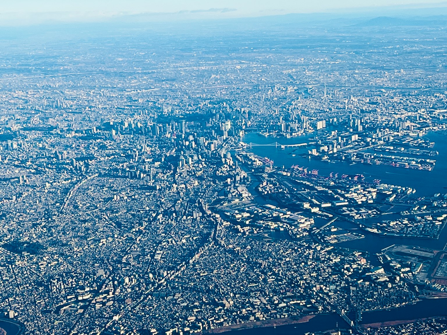 มุมมองทางอากาศของโตเกียวที่มีวิวเมืองและท่าเรือที่กว้างใหญ่