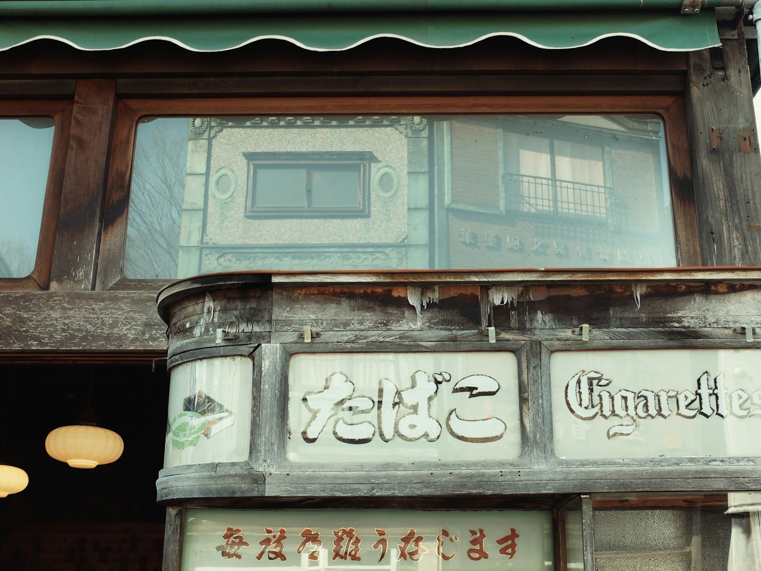 Traditional Japanese storefront featuring wooden signage with Japanese and French text