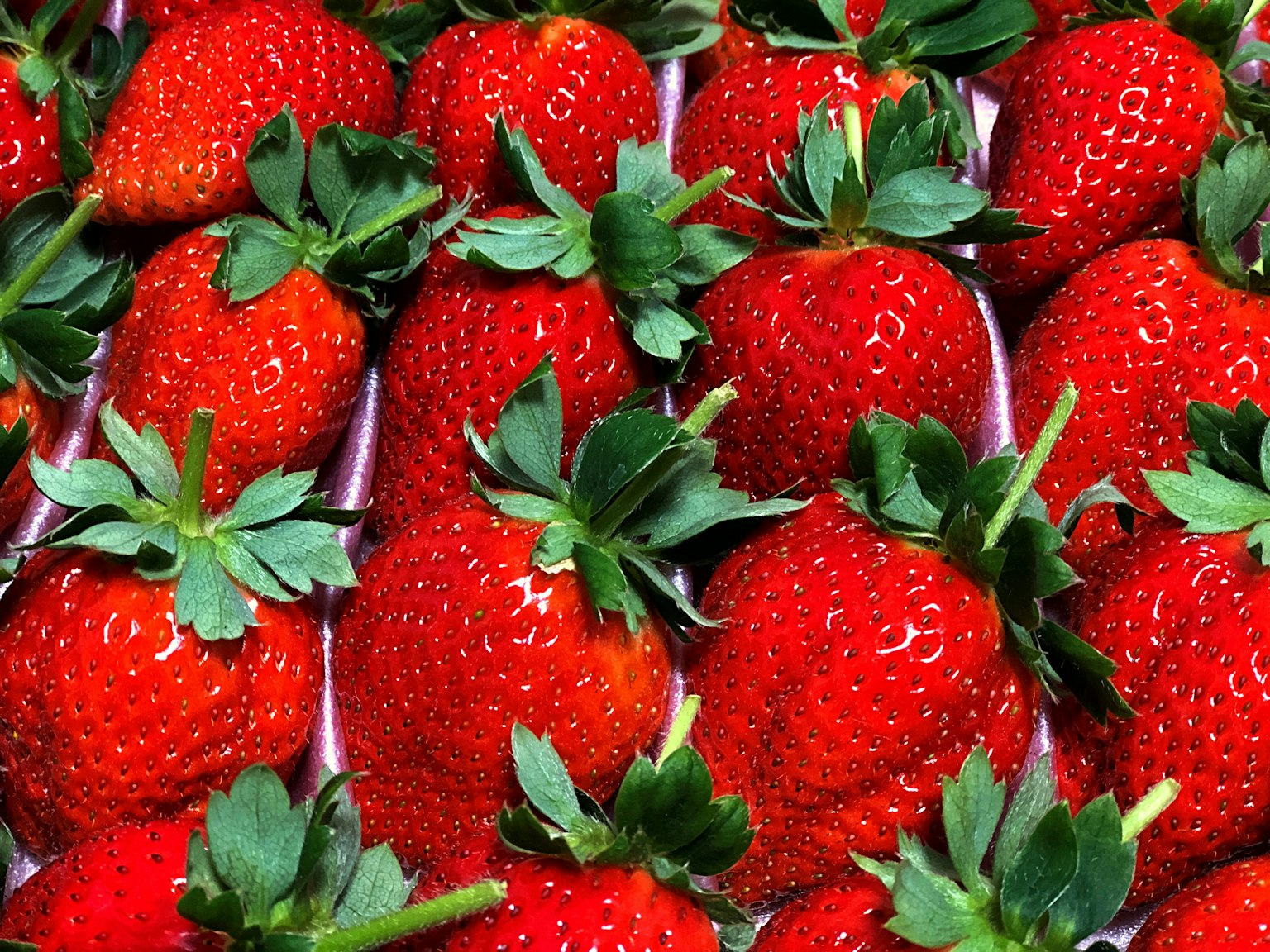 Fresh red strawberries arranged closely together
