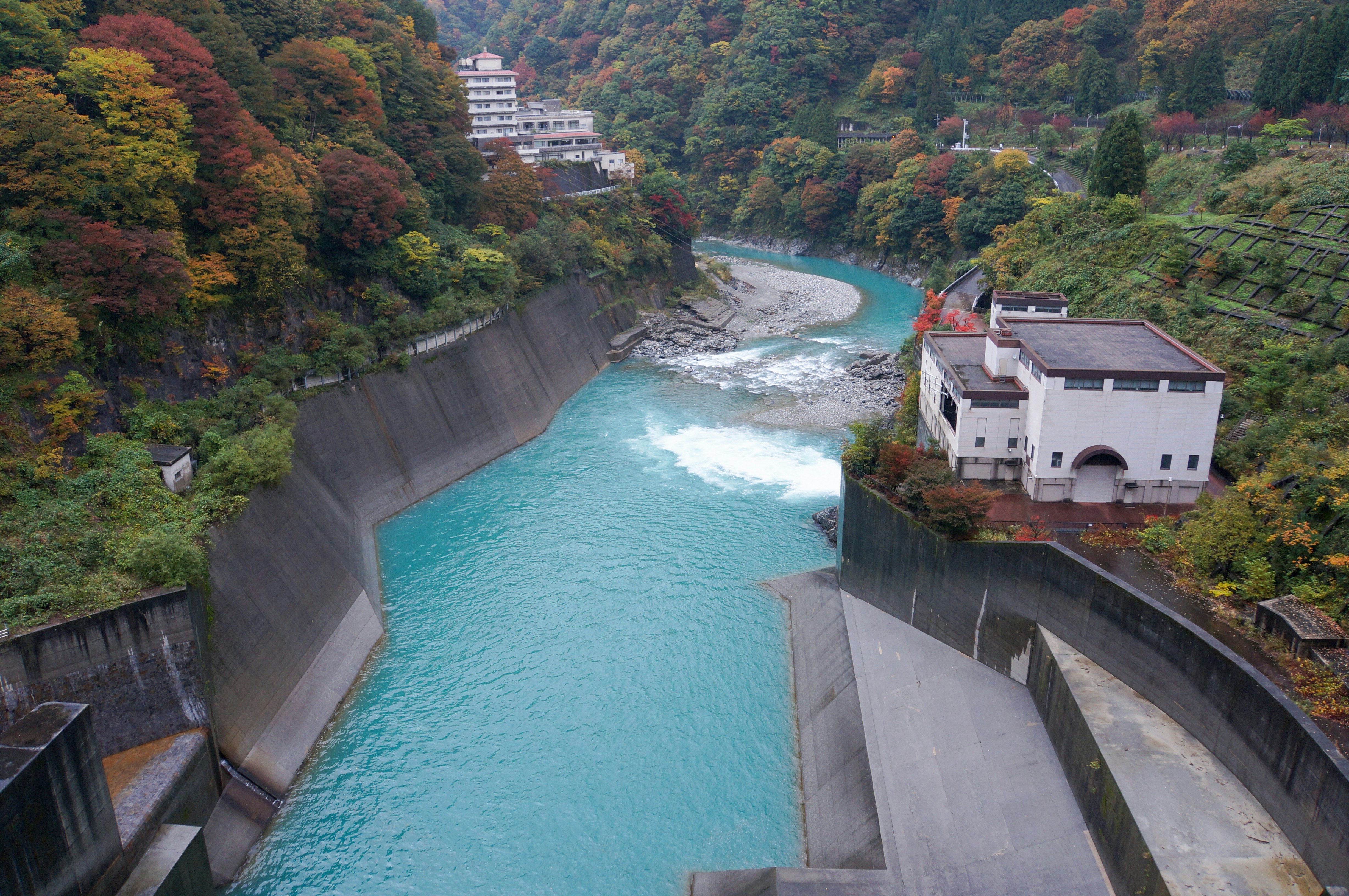 渓谷に沿うダムと放水路のある川の景観