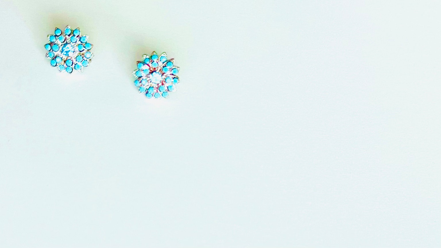 Boucles d'oreilles en pierres précieuses bleues sur un fond blanc