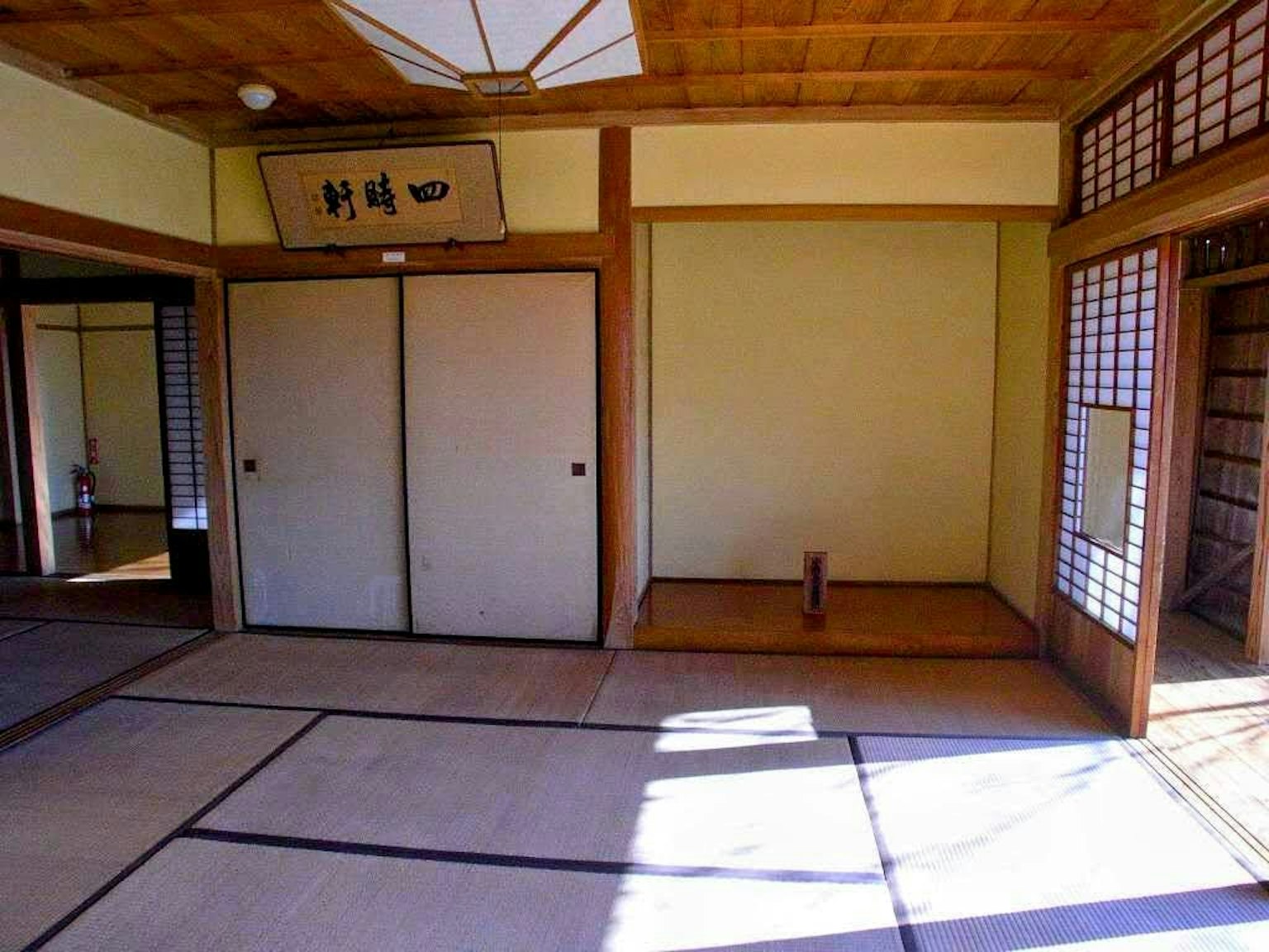 Interior of a traditional Japanese room with tatami mats and shoji screens allowing bright light