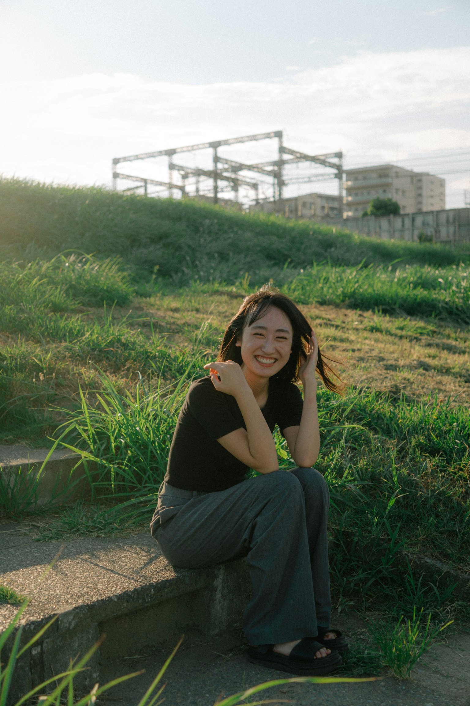 ผู้หญิงยิ้มอยู่บนบันไดในสวนสีเขียว