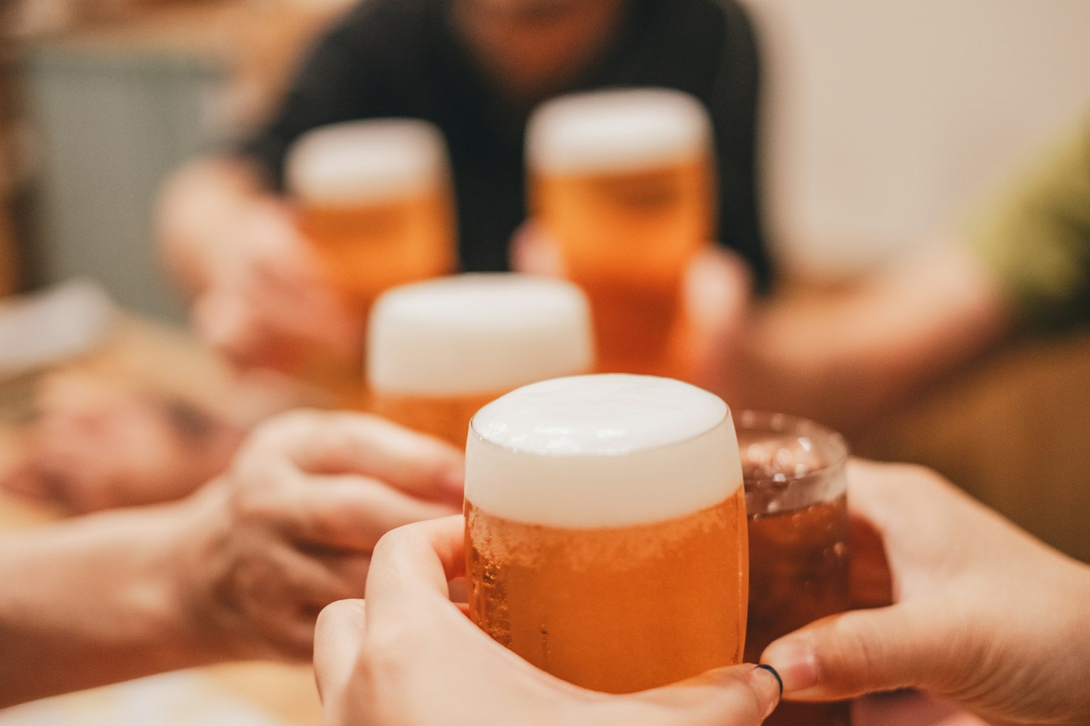 在社交聚会上举着啤酒杯的手