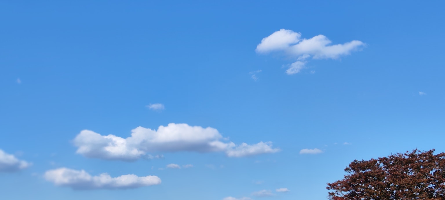 Clear blue sky with fluffy white clouds