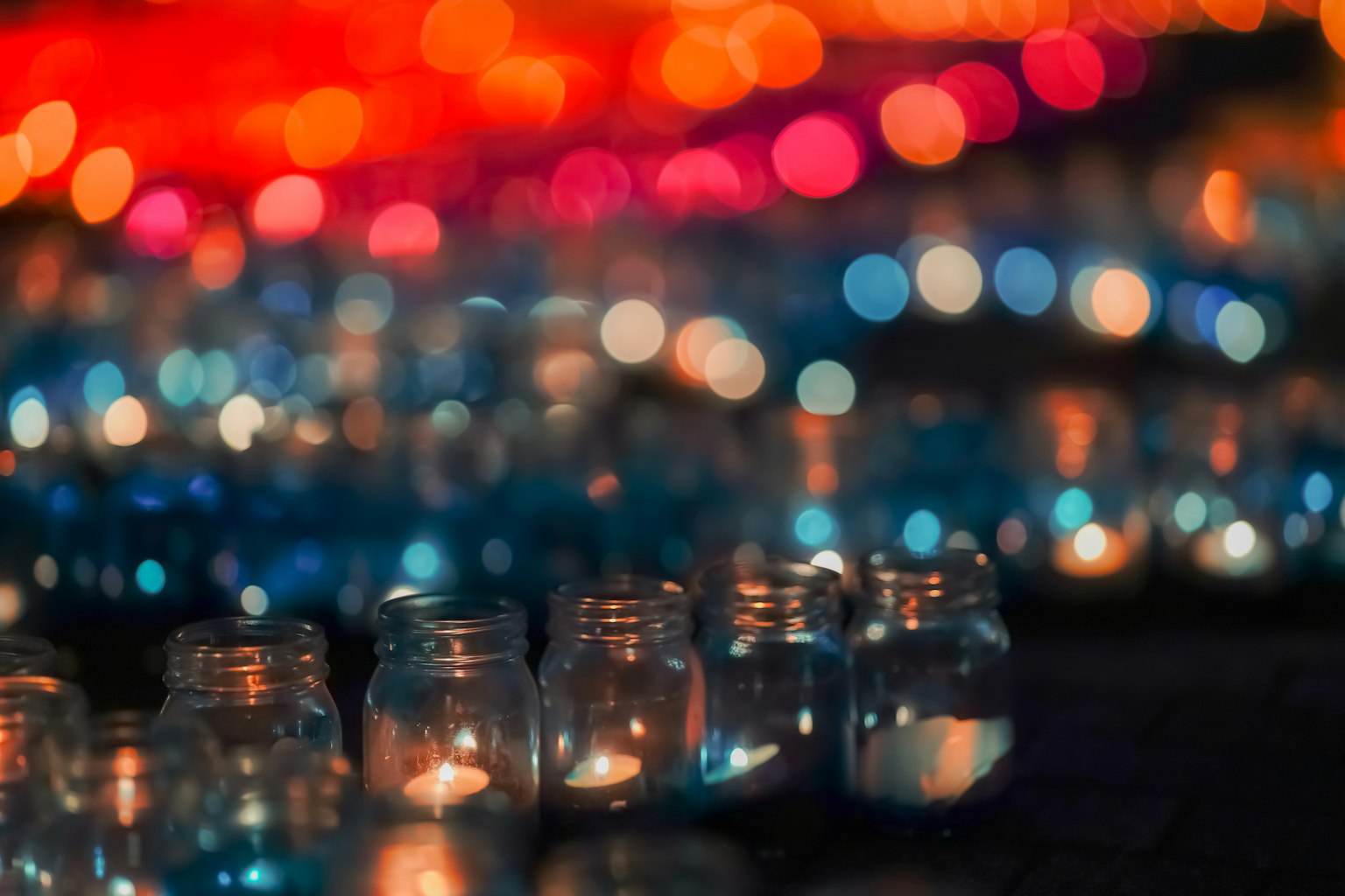 Barattoli con candele illuminati da luci sfocate colorate