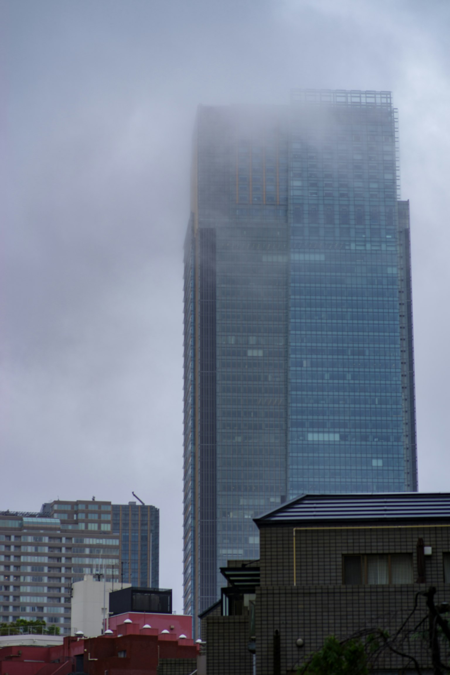 Grattacielo avvolto nella nebbia con cielo nuvoloso
