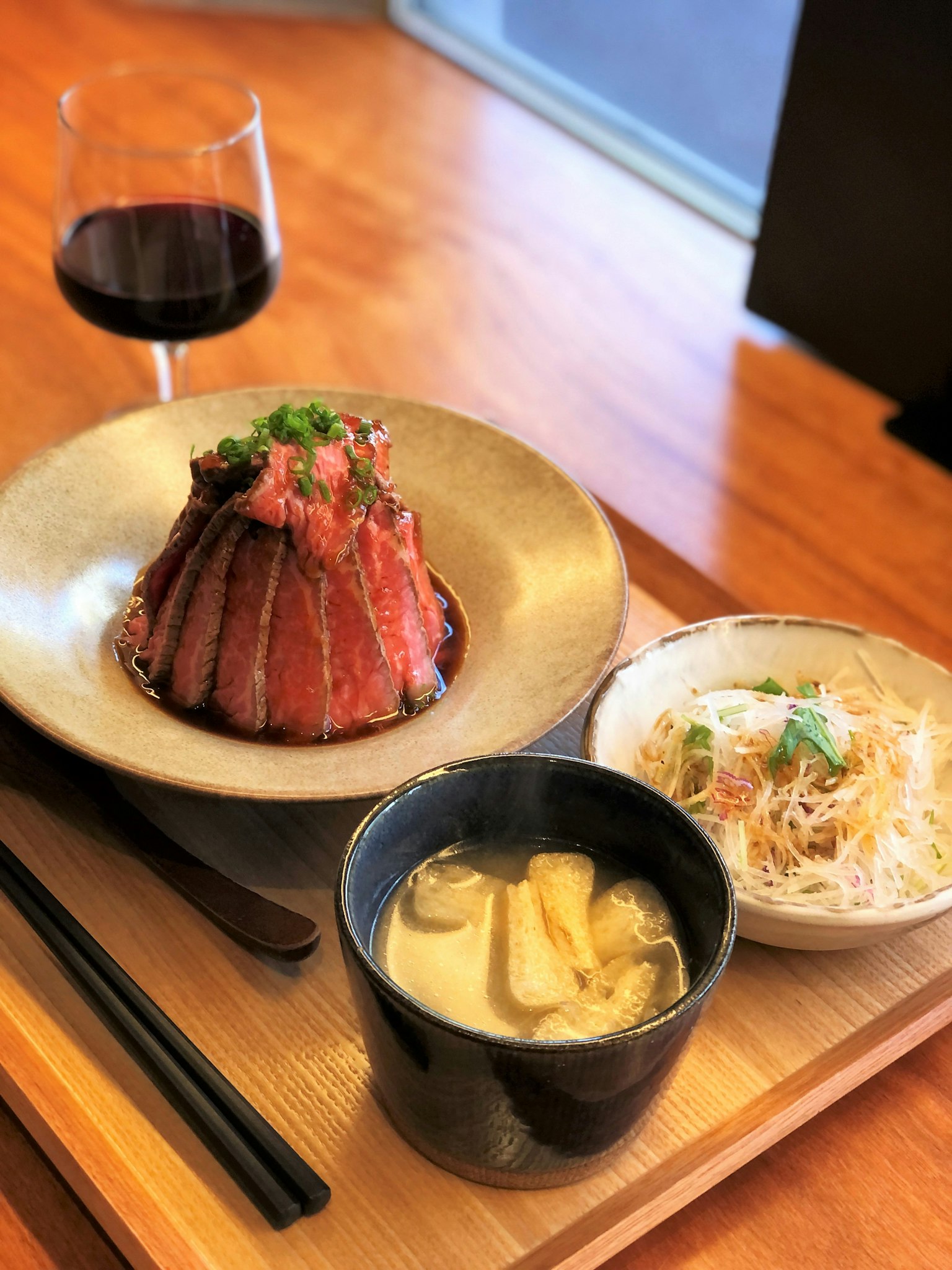 Une assiette de cuisine japonaise joliment présentée avec un plat de viande et des accompagnements