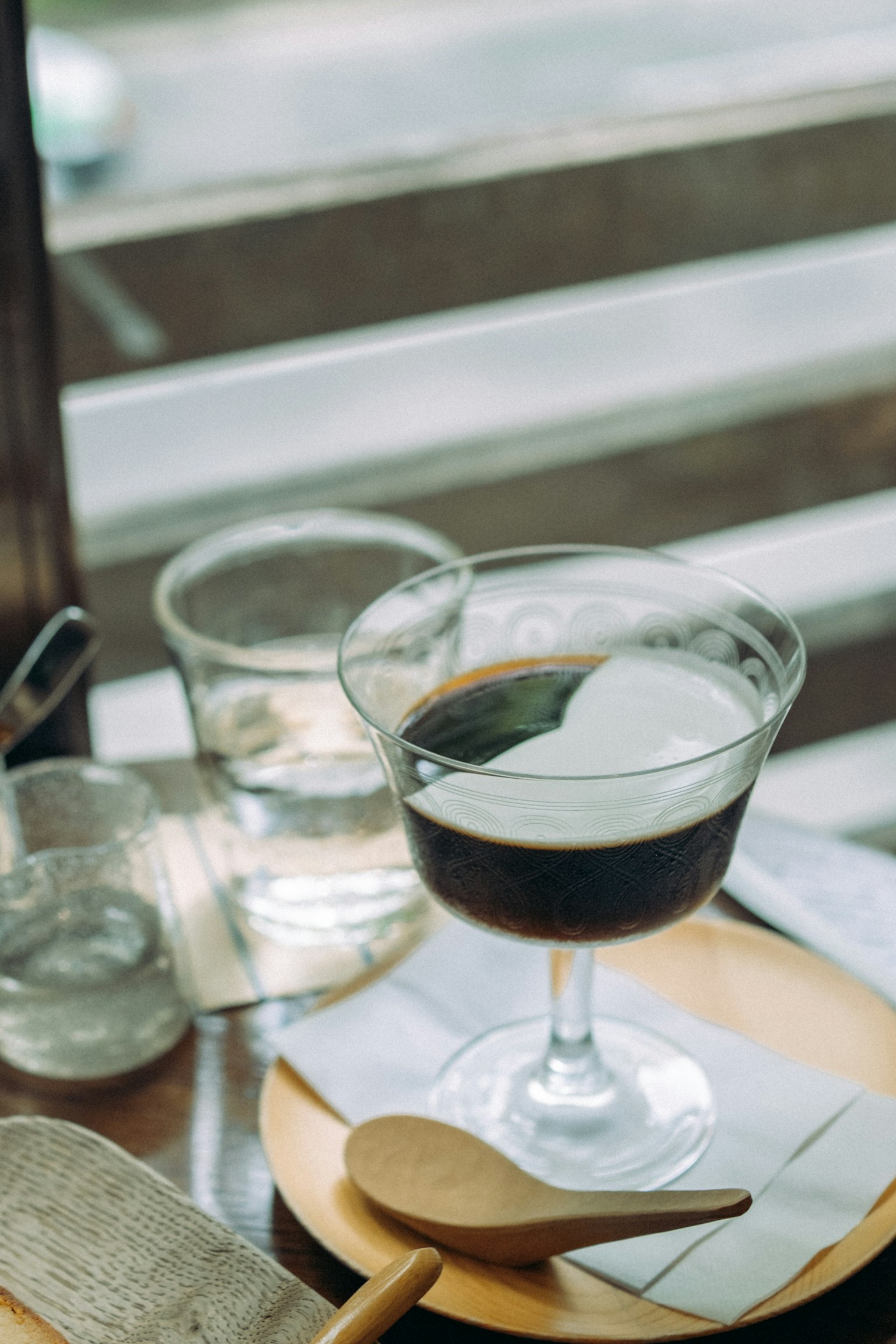 A cocktail of coffee and cream served in a glass on a wooden table