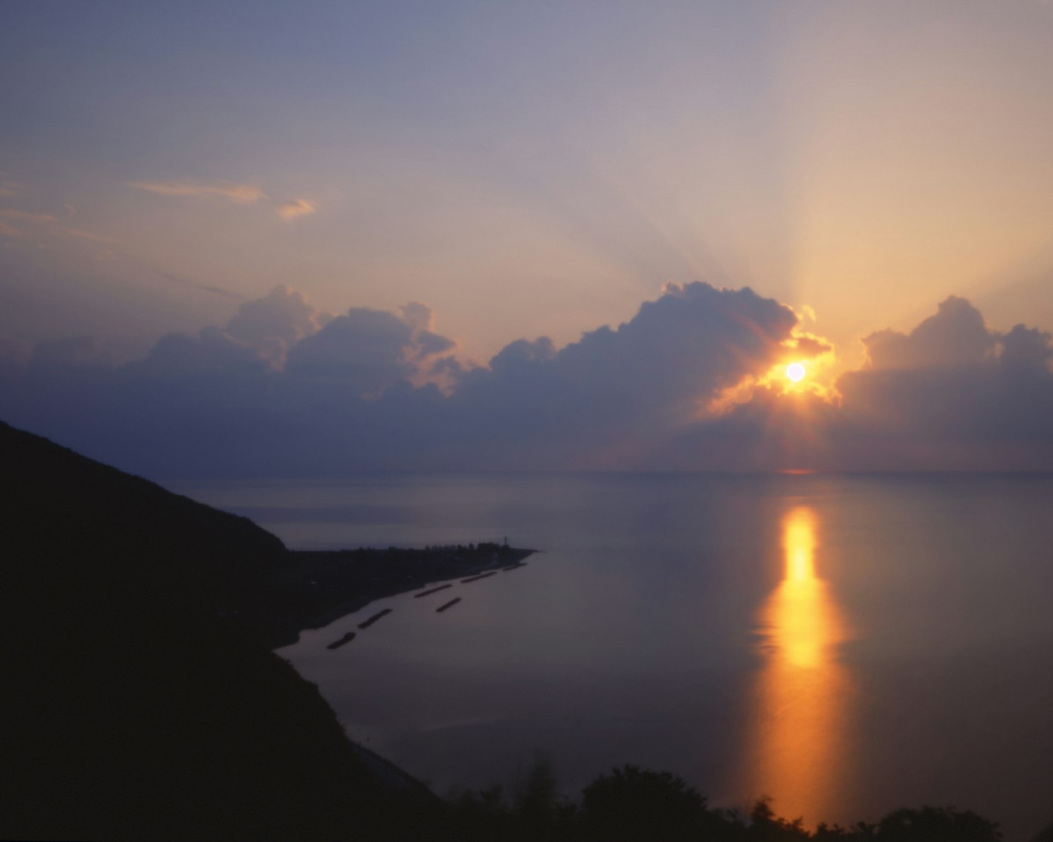 Beautiful seascape with sunset rays shining through clouds