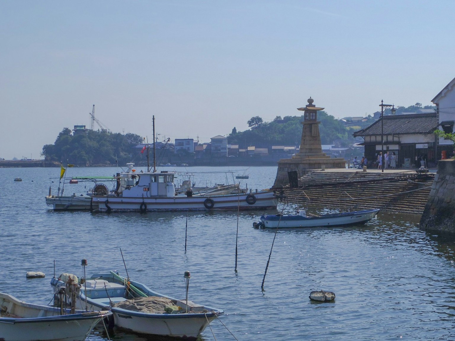 Puerto sereno con pequeños barcos y un faro