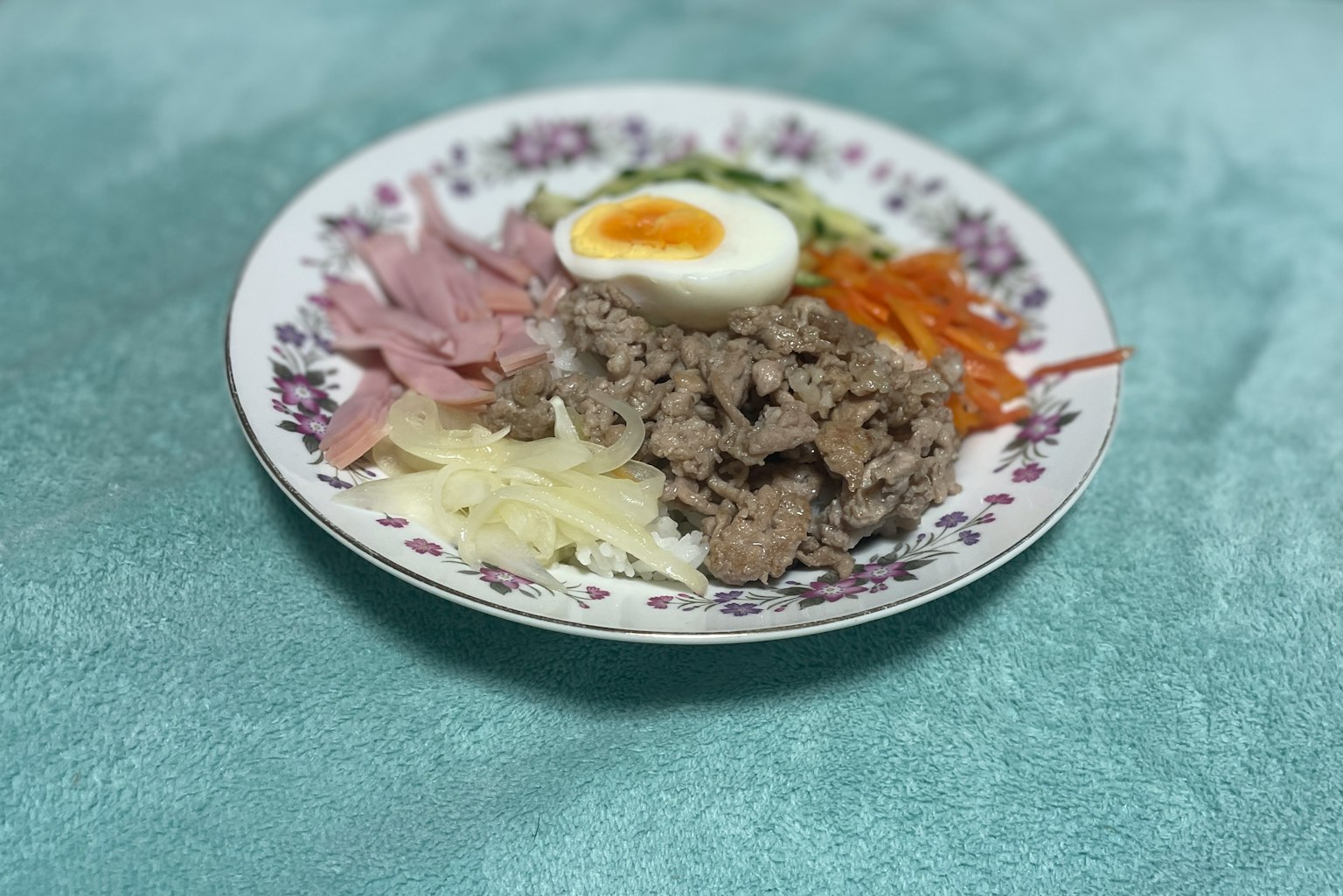 Ein Teller mit schön angerichtetem Rindfleisch, Schinken, gekochtem Ei und Gemüsesalat