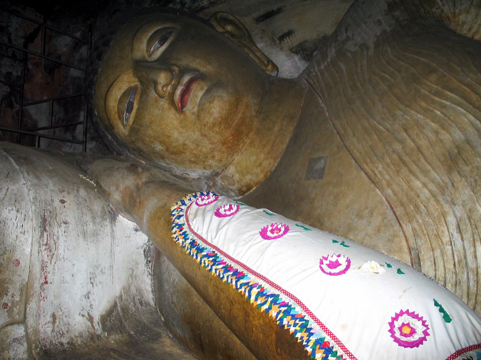 Close-up patung Buddha besar dengan detail pakaian yang rumit
