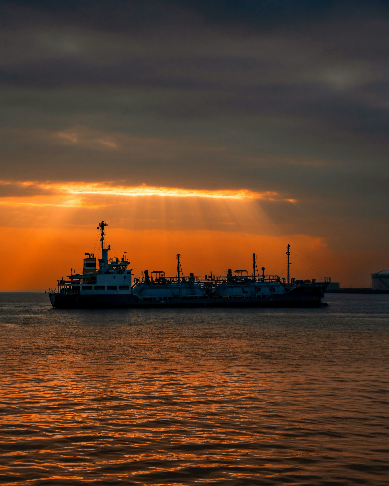 A ship silhouetted against the sunset with calm waters