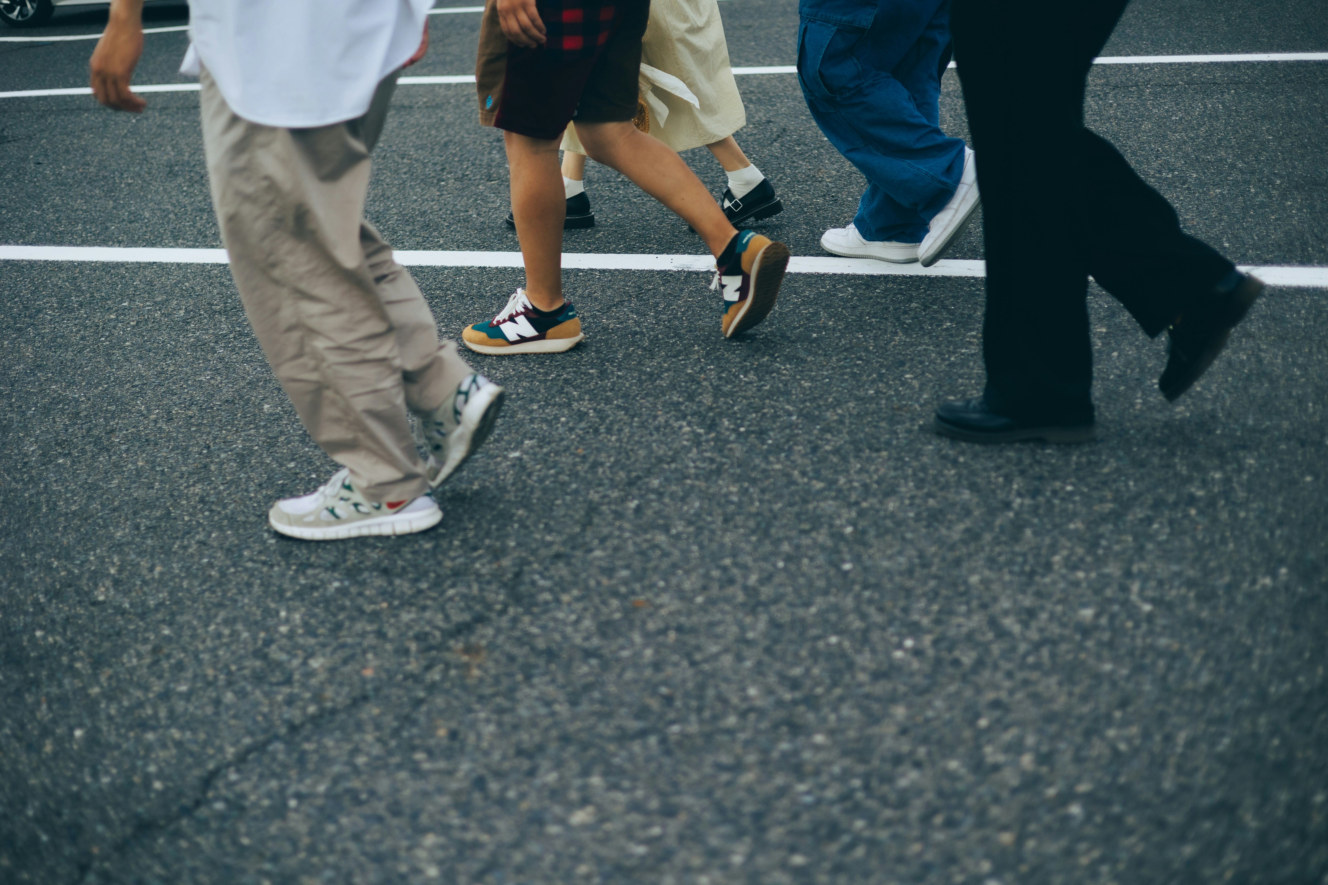 feet of people walking on a crosswalk