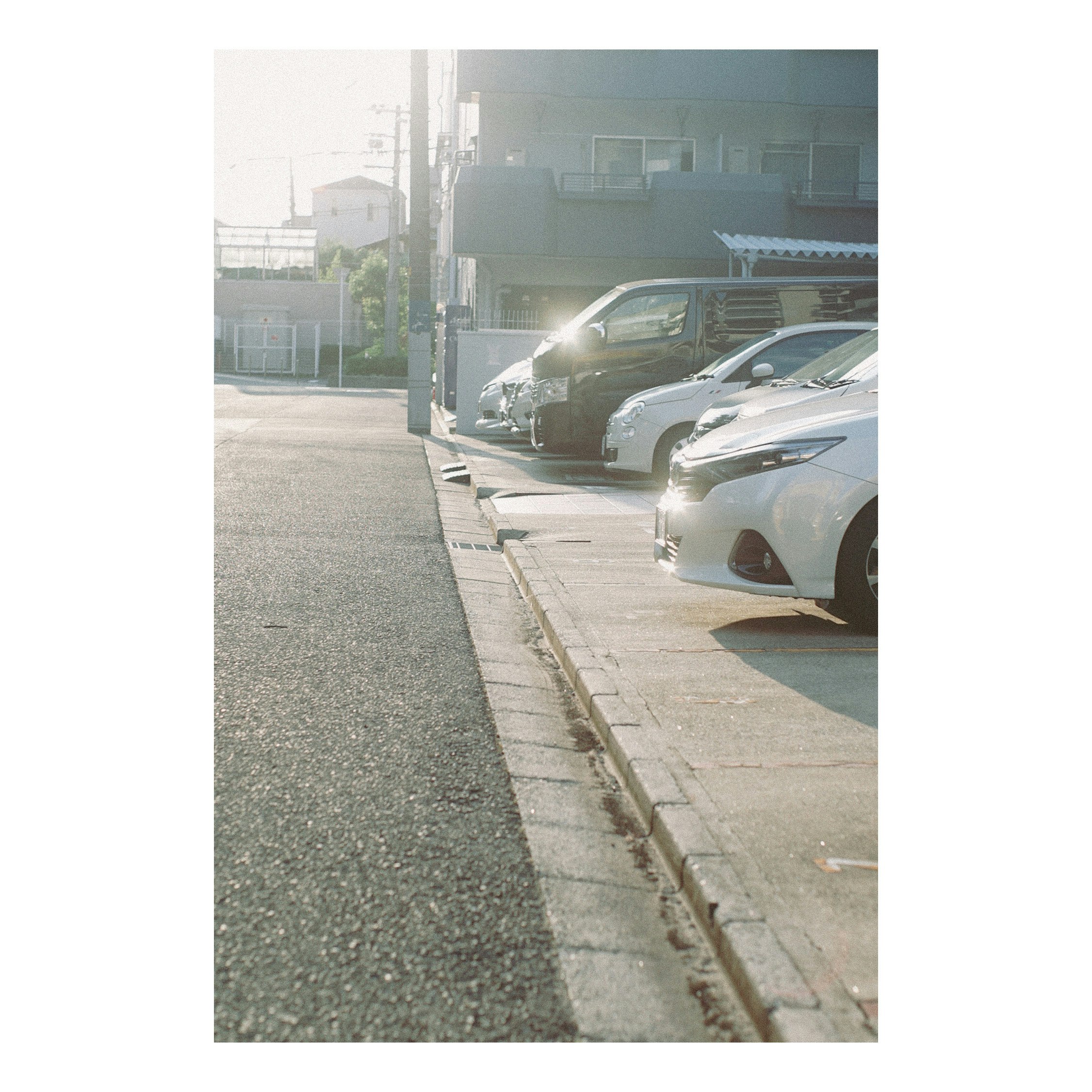 路肩に並ぶ車と駐車場の街並み