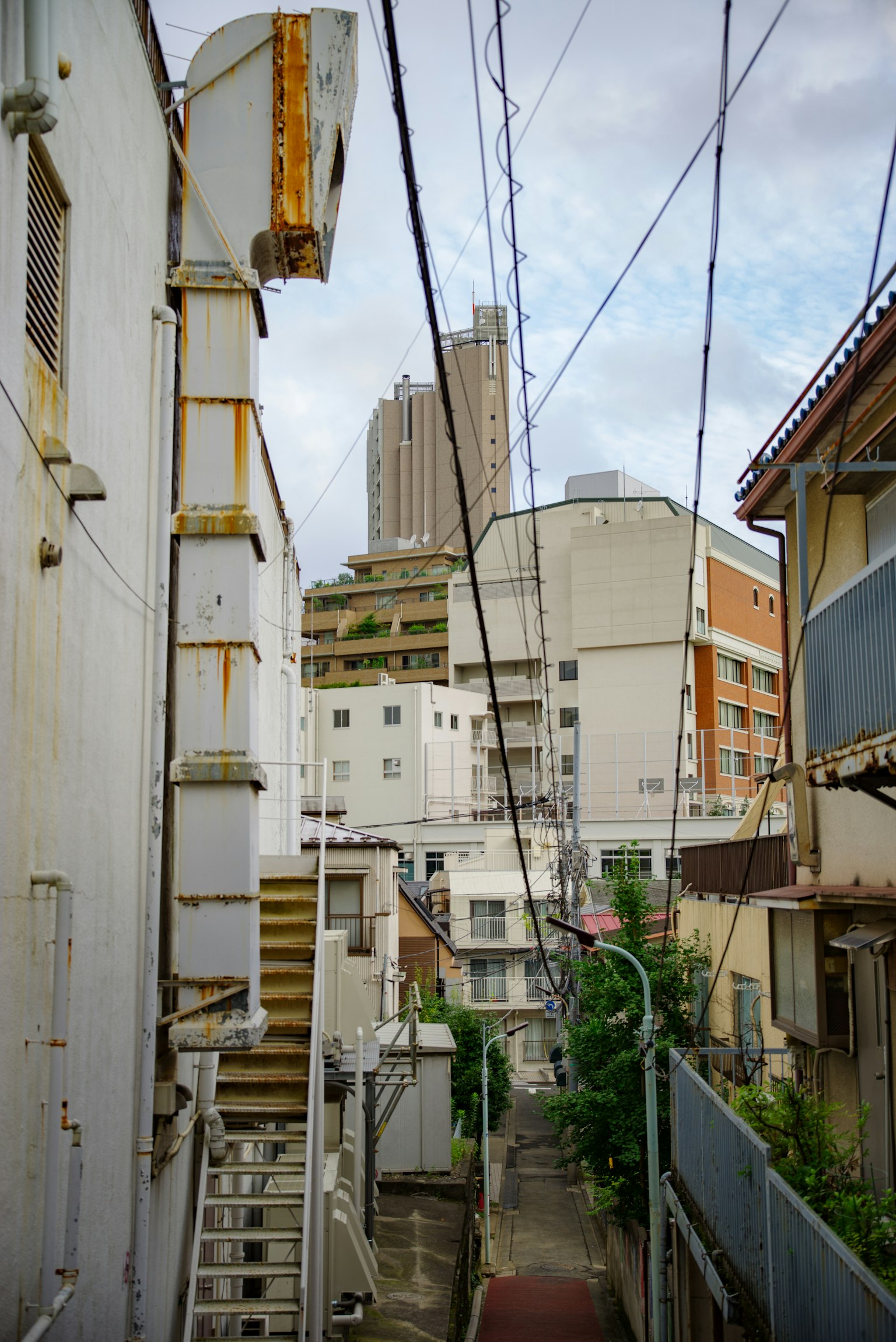 Narrow alleyway with visible high-rise buildings in an urban setting