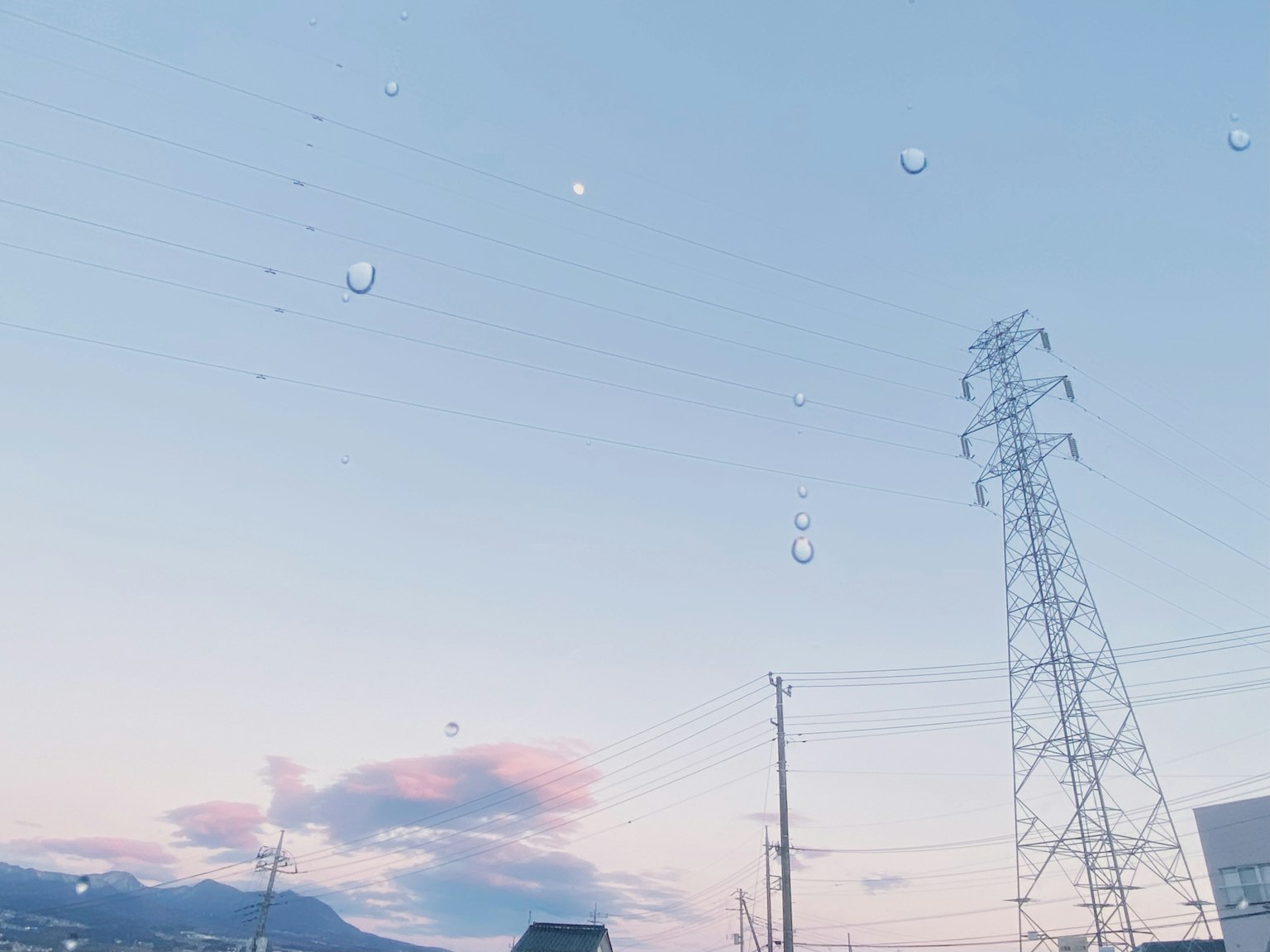 Una vista panoramica con gocce su un cielo blu e linee elettriche