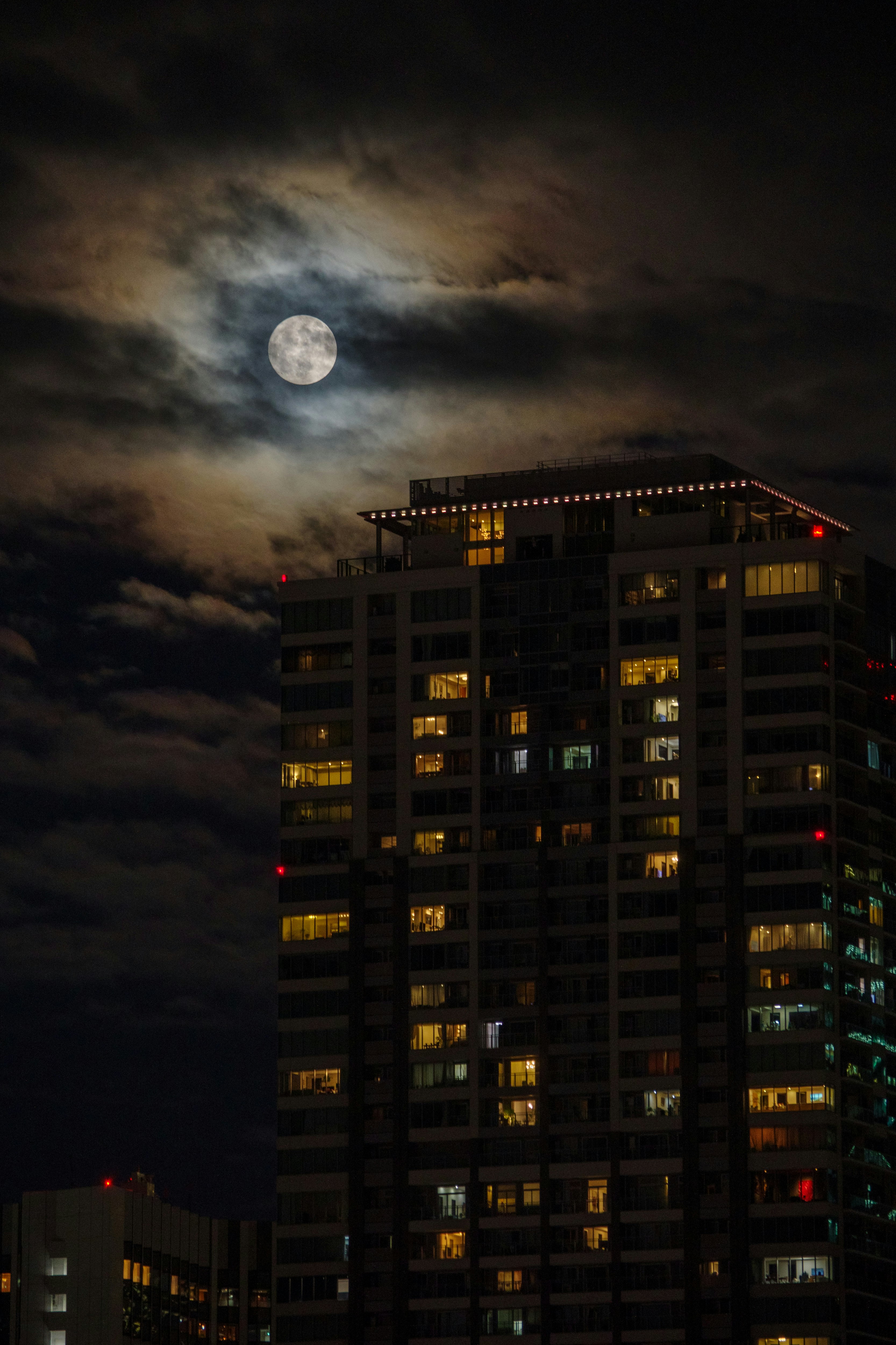 city skyline with high-rise buildings under a full moon