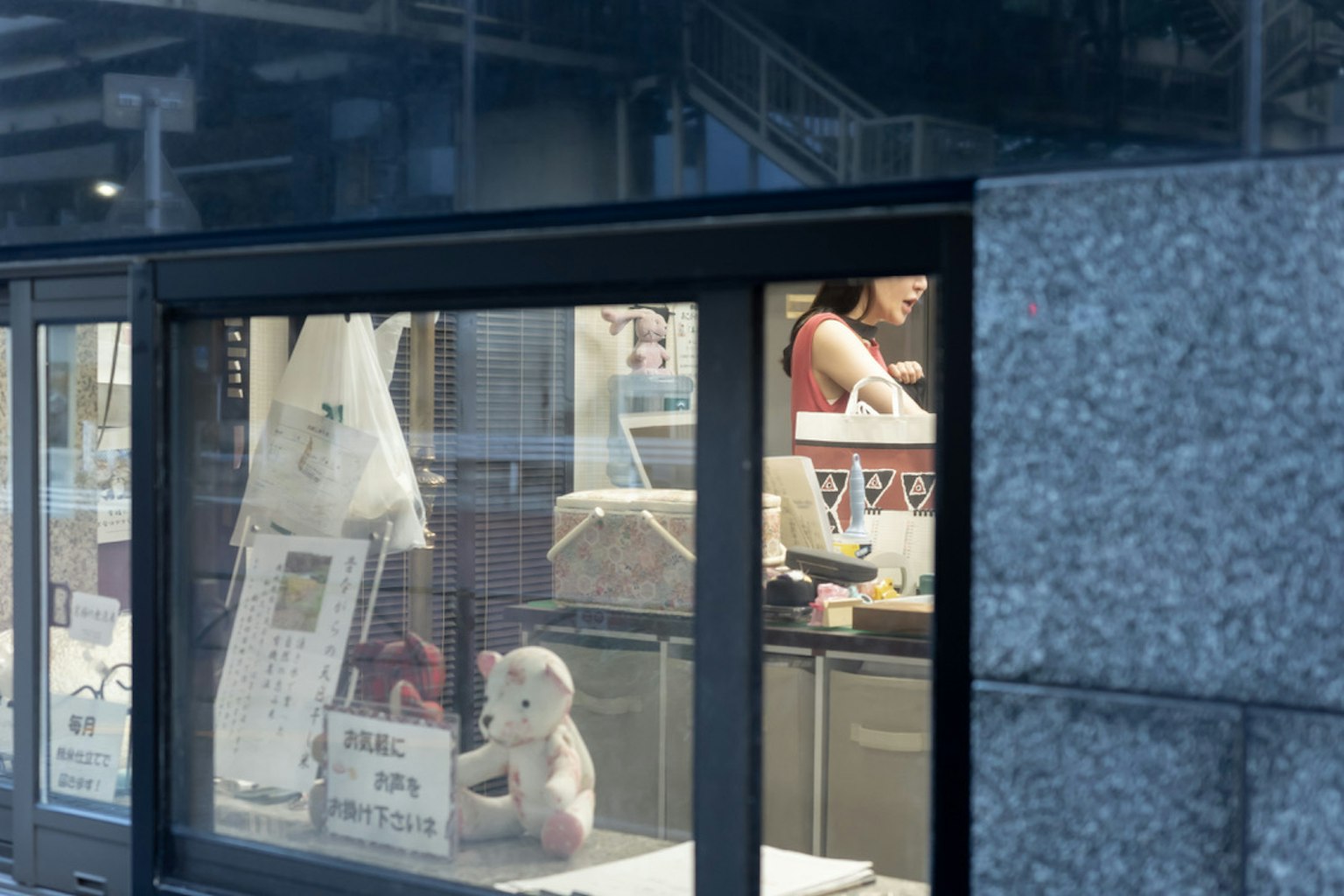 Vista del interior de una tienda a través del cristal con una empleada