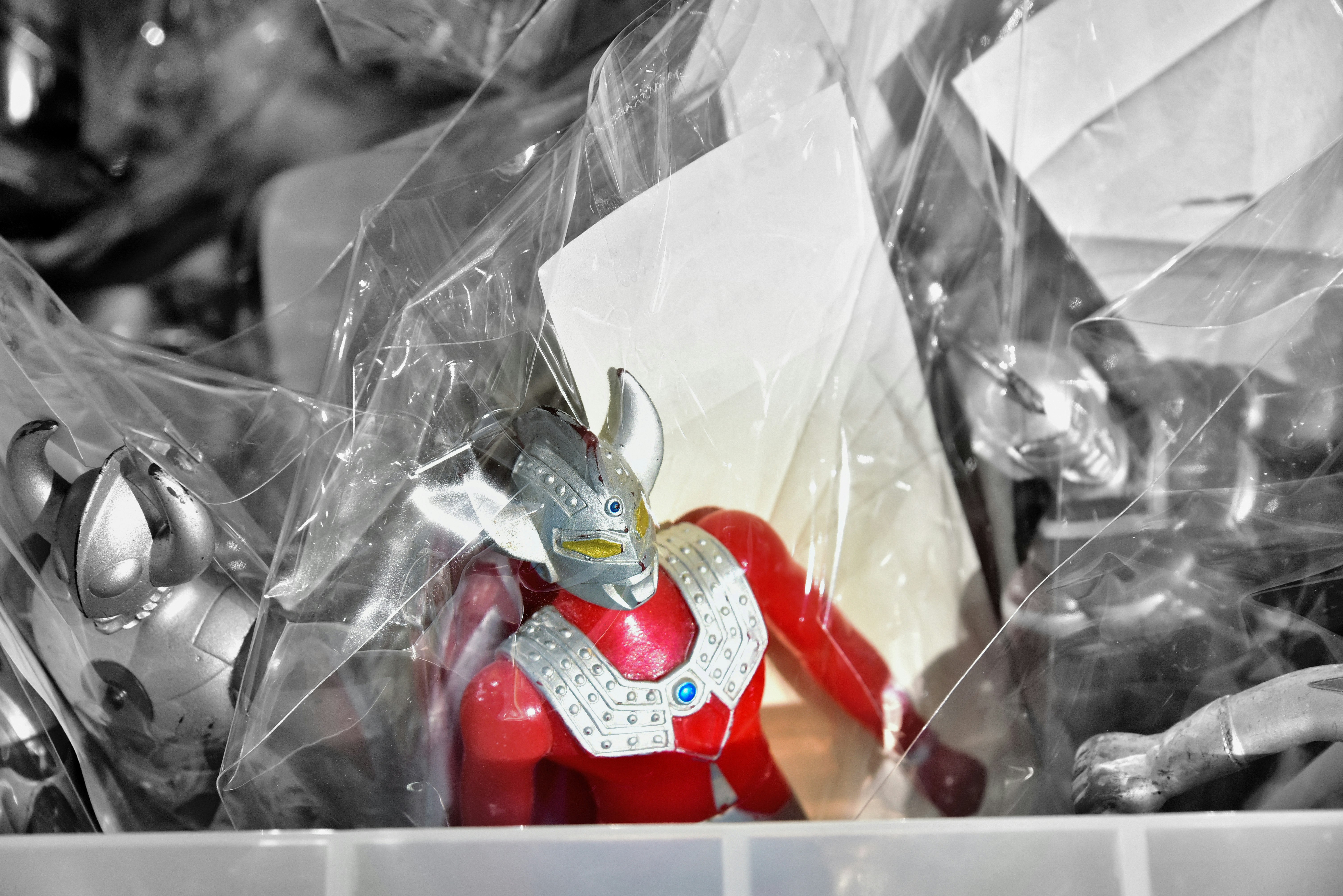 透明な袋越しに並ぶウルトラマン風の人形と小物