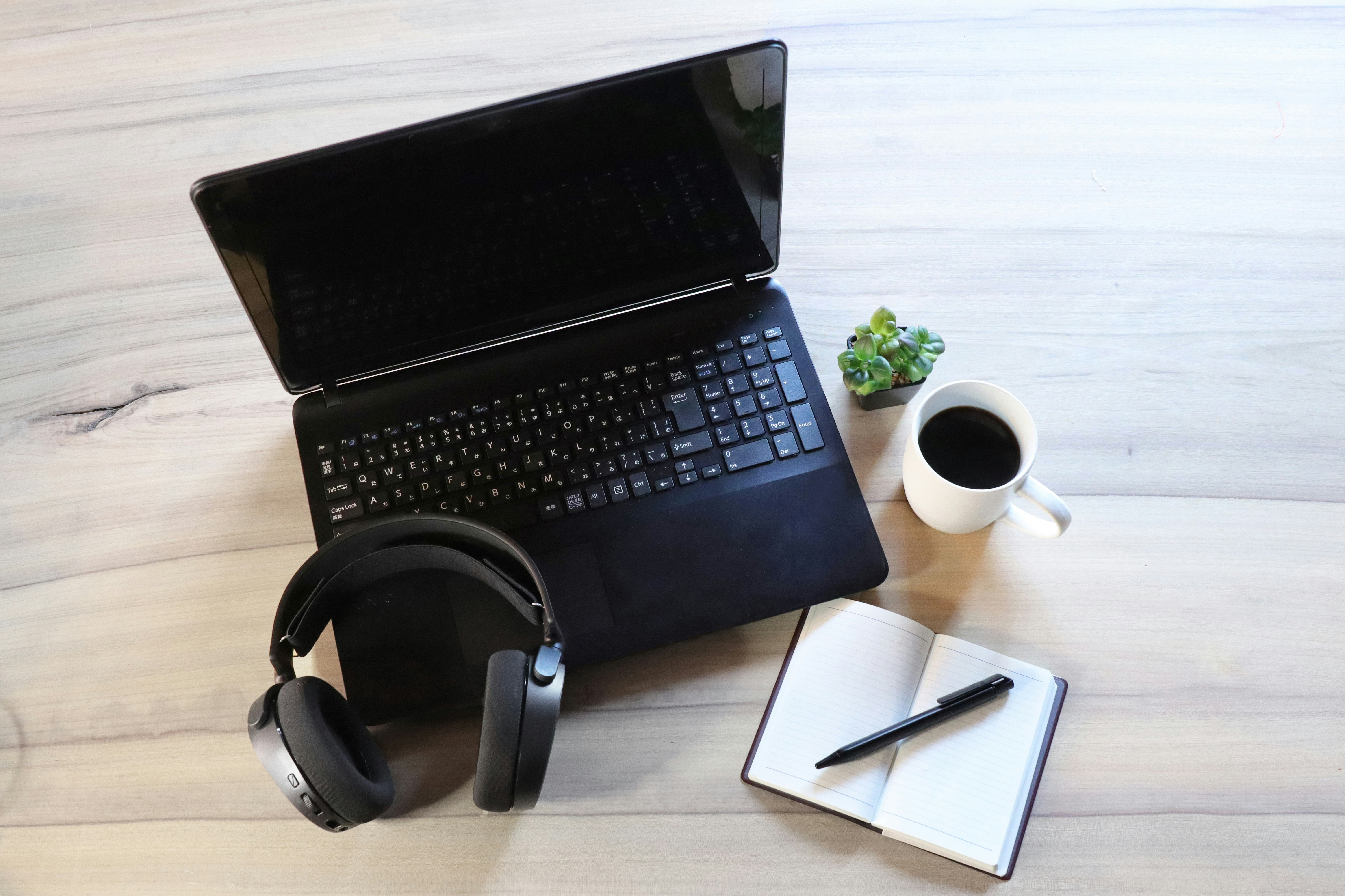 ノートPCとヘッドホン、コーヒーのあるデスクのワークスペース