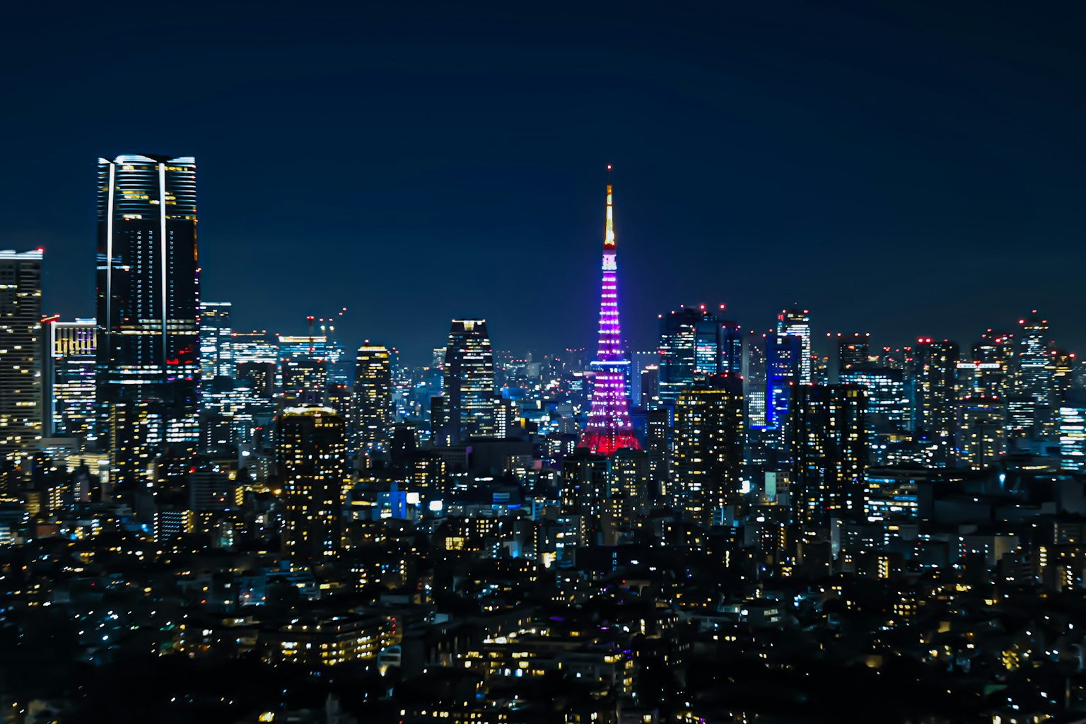 东京塔在夜晚被点亮，展示出迷人的城市天际线