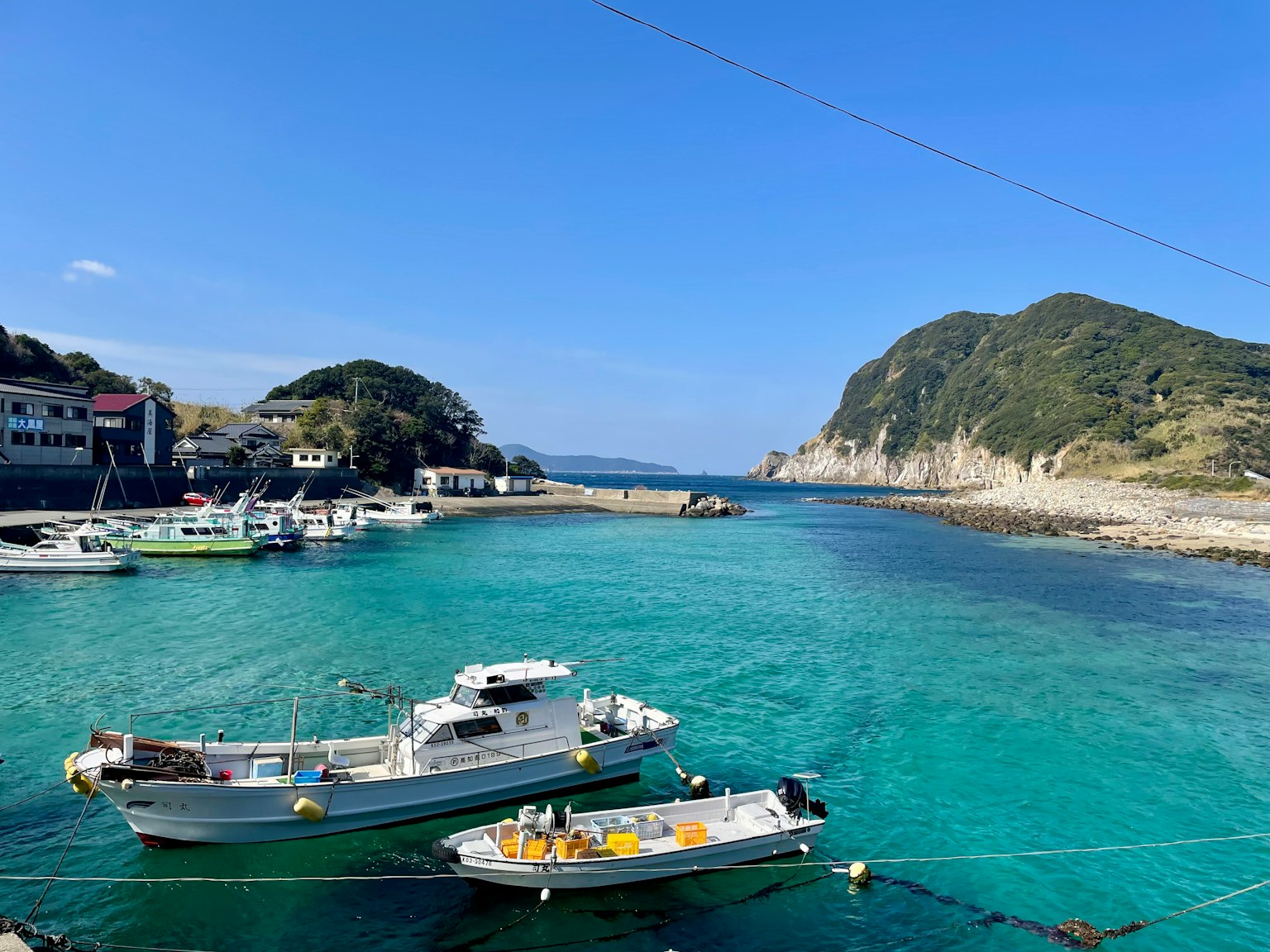 Vista panoramica di un porto con acqua turchese e piccole barche da pesca