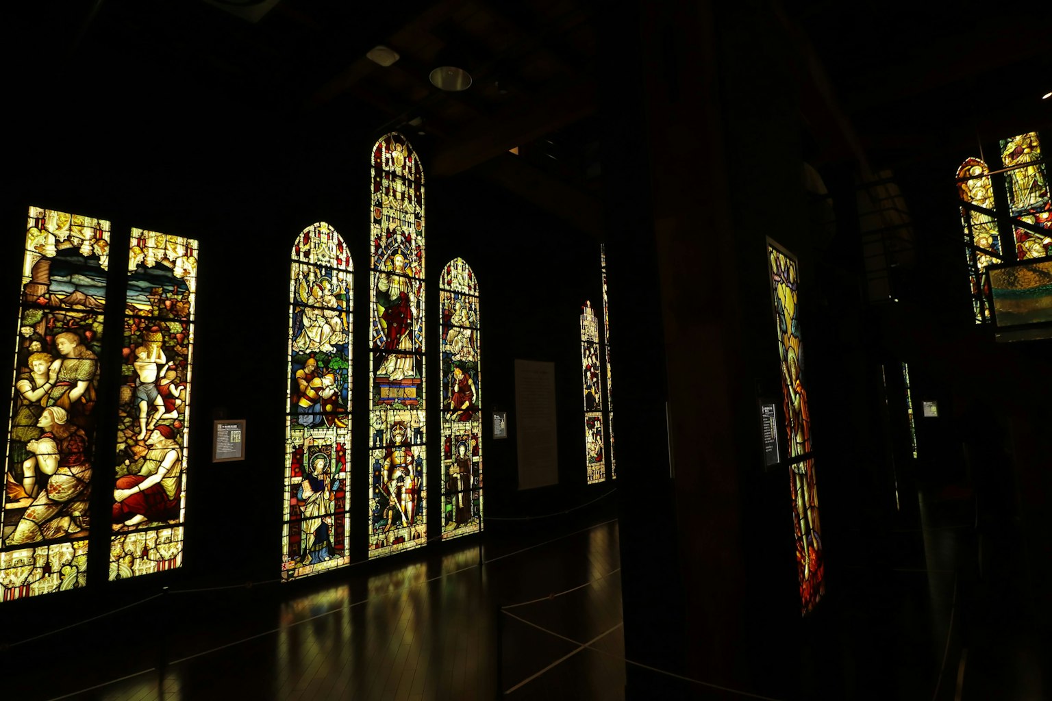 De belles fenêtres en vitrail disposées dans une pièce sombre