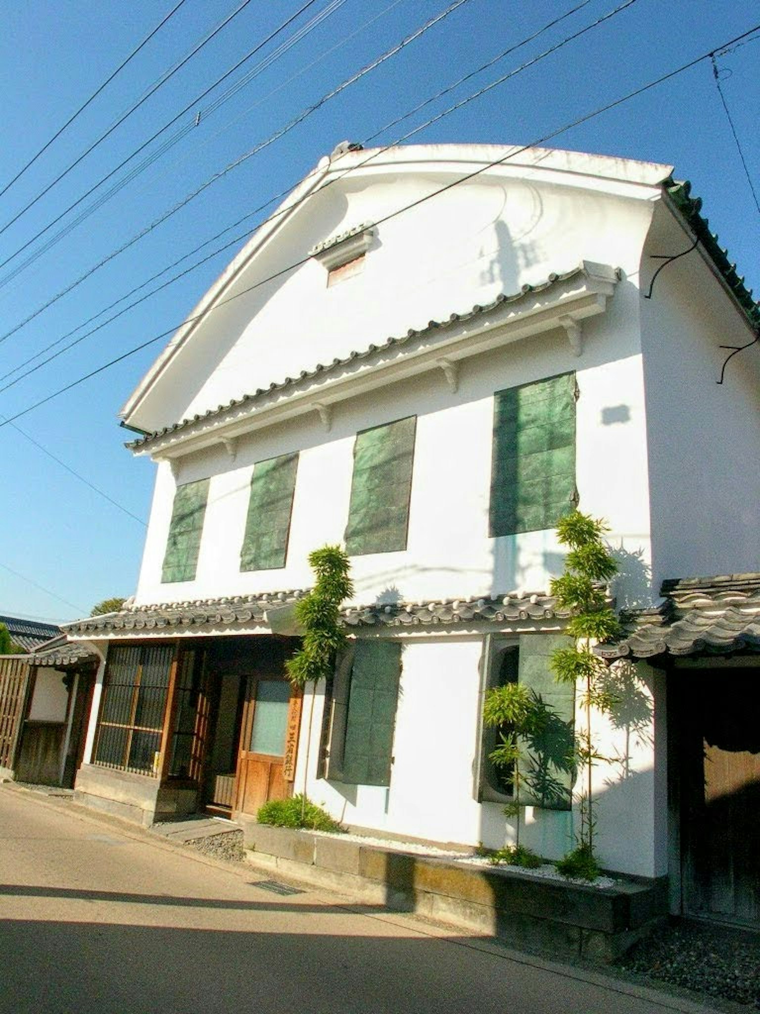 Rumah tradisional Jepang dengan eksterior putih dan jendela hijau