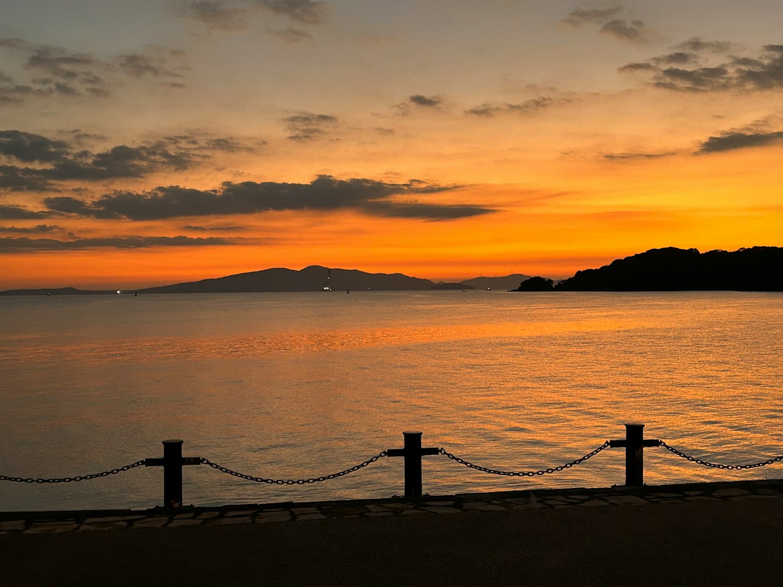 Sunset over a calm sea with distant island
