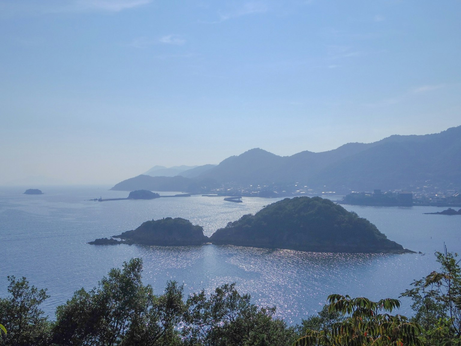 ทิวทัศน์ที่สวยงามของทะเลสีน้ำเงินและเกาะต่างๆ พร้อมภูเขาที่อยู่ไกล