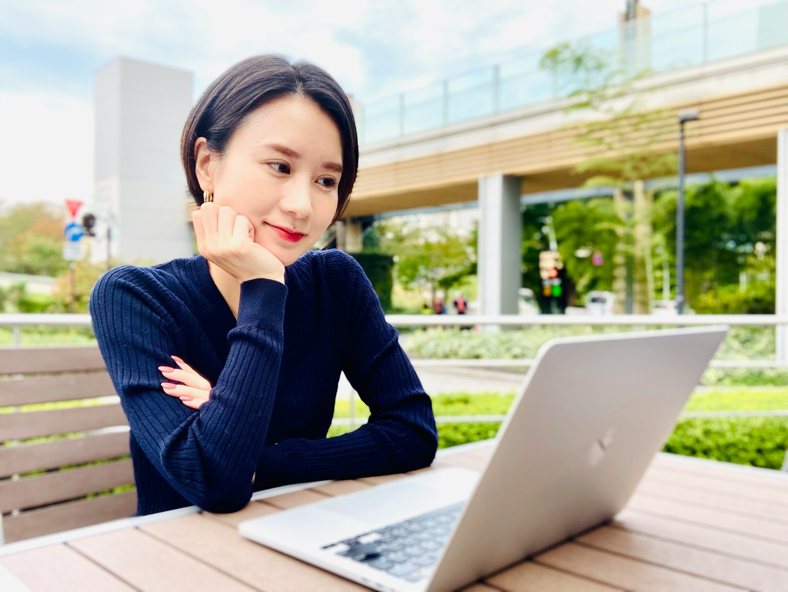 Frau nutzt einen Laptop an einem Tisch im Park