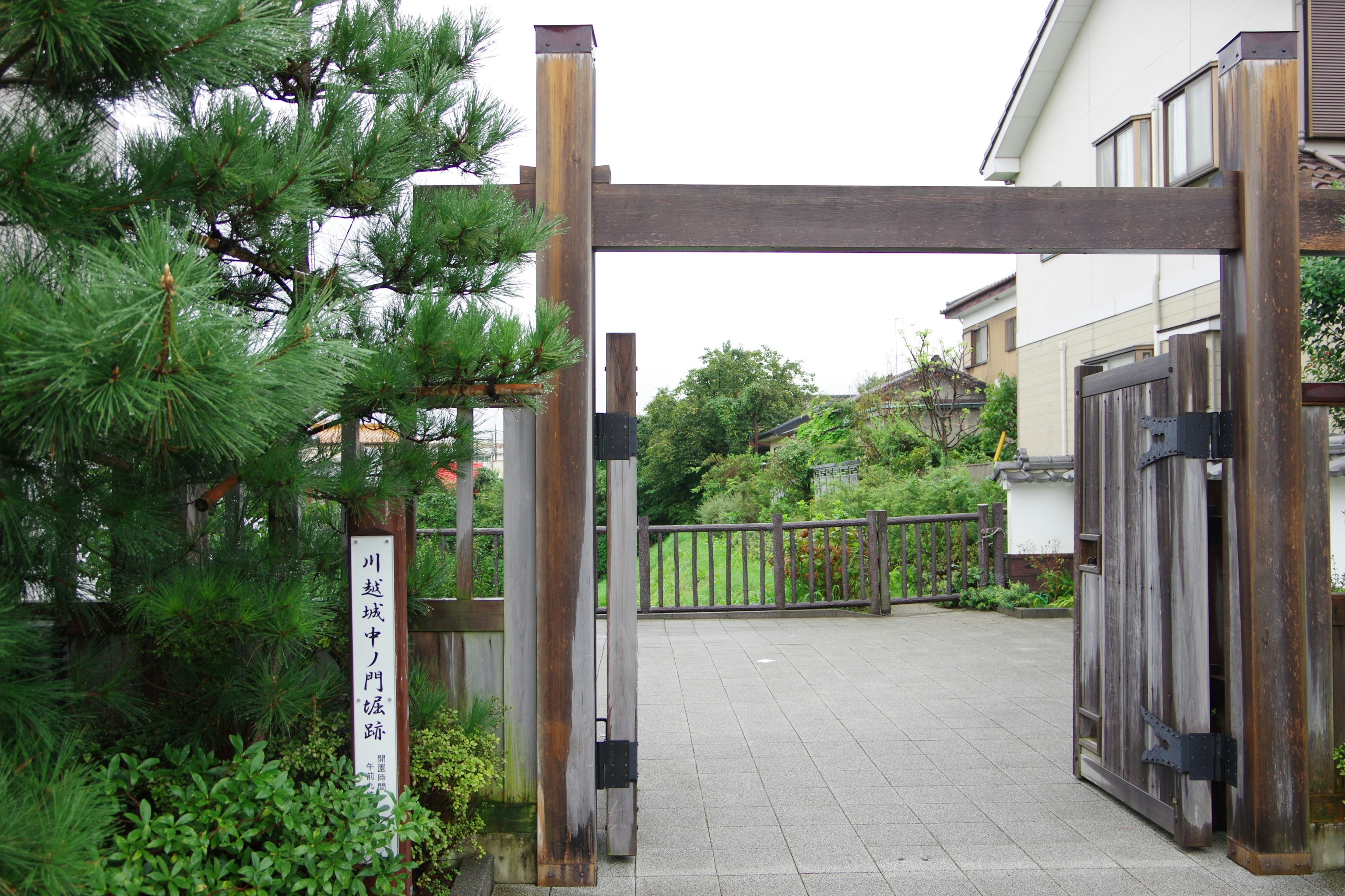 Allée de jardin avec clôture en bambou et portail en bois