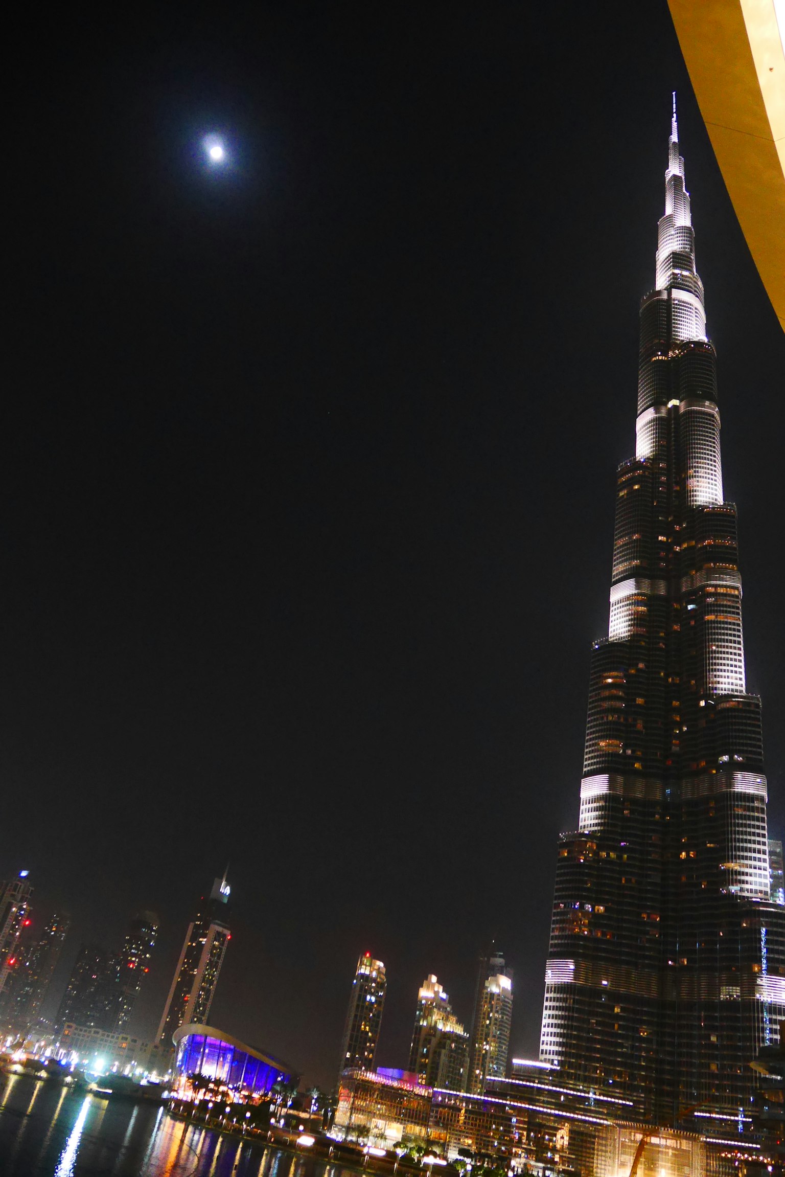 Burj Khalifa che svetta su Dubai di notte con una luna crescente